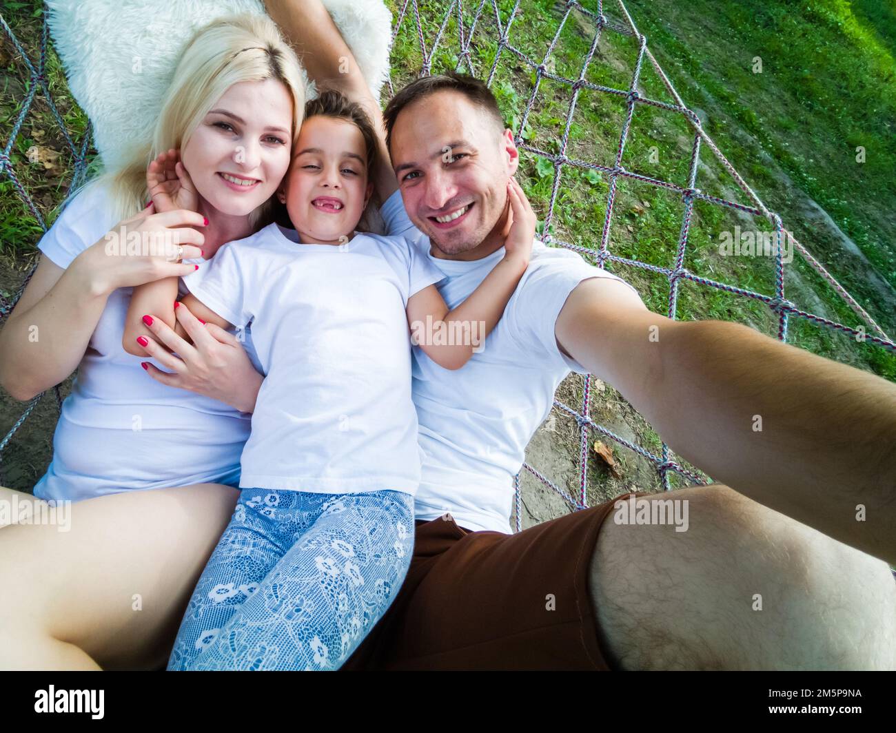 Familie gemeinsam im Garten Hängematte entspannen Stockfoto