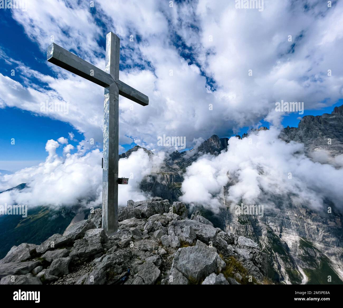 Ein Kreuz auf einem felsigen Gipfel an einem bewölkten Tag Stockfoto