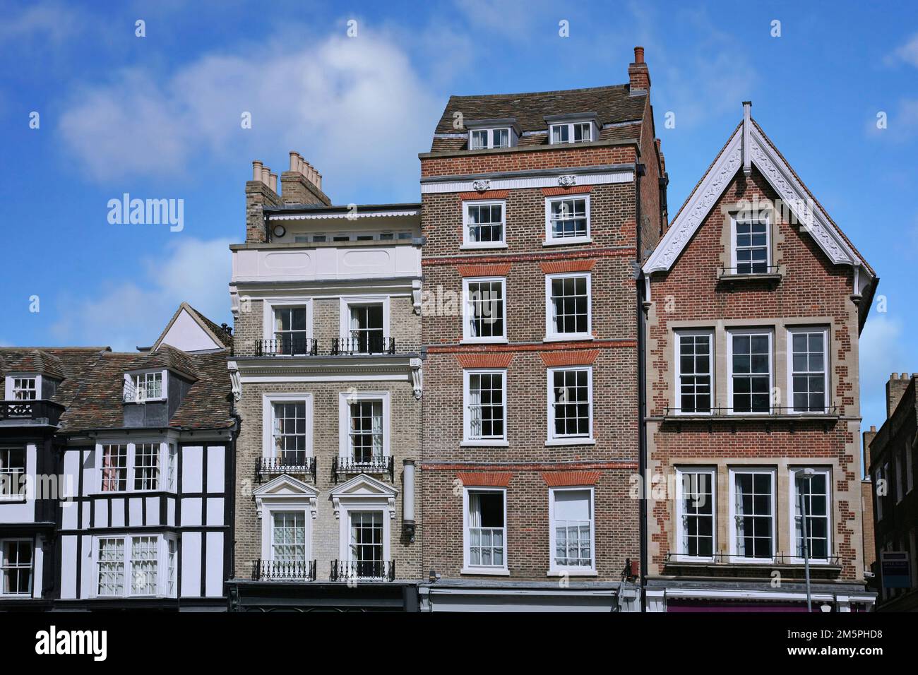 Eine Reihe hoher, schmaler alter Gebäude mit Apartments oben und Geschäften darunter, King's Parade, Cambridge, England Stockfoto