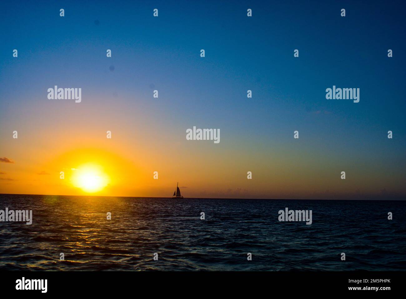 Sonnenaufgang/Sonnenuntergang in der Karibik mit einem Segelboot Stockfoto