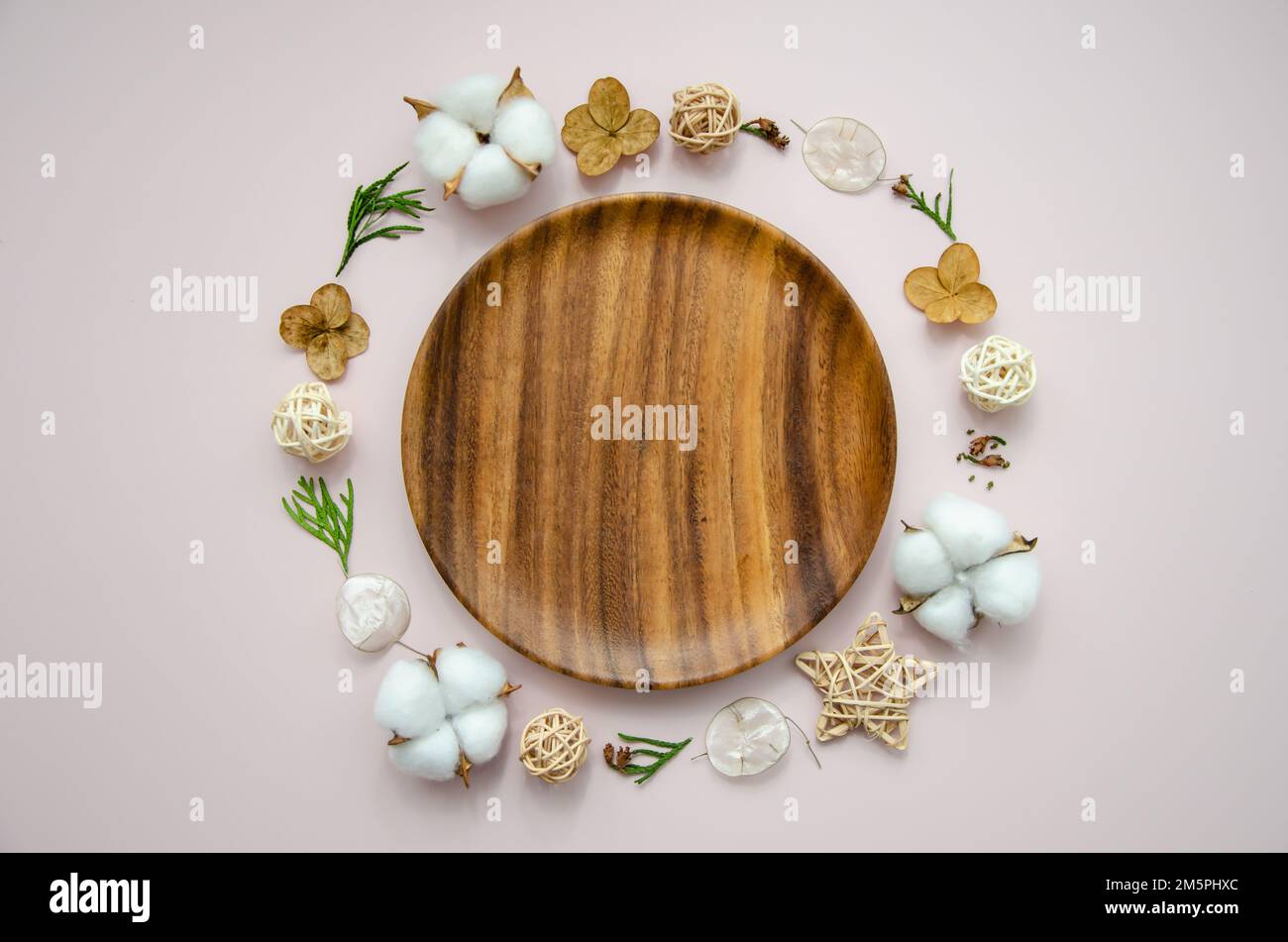 Festliche Weihnachtskarte auf Holzteller mit getrockneten Blumen, Thuja-Ästen, Wattestäbchen und StrohSternen, Draufsicht Stockfoto