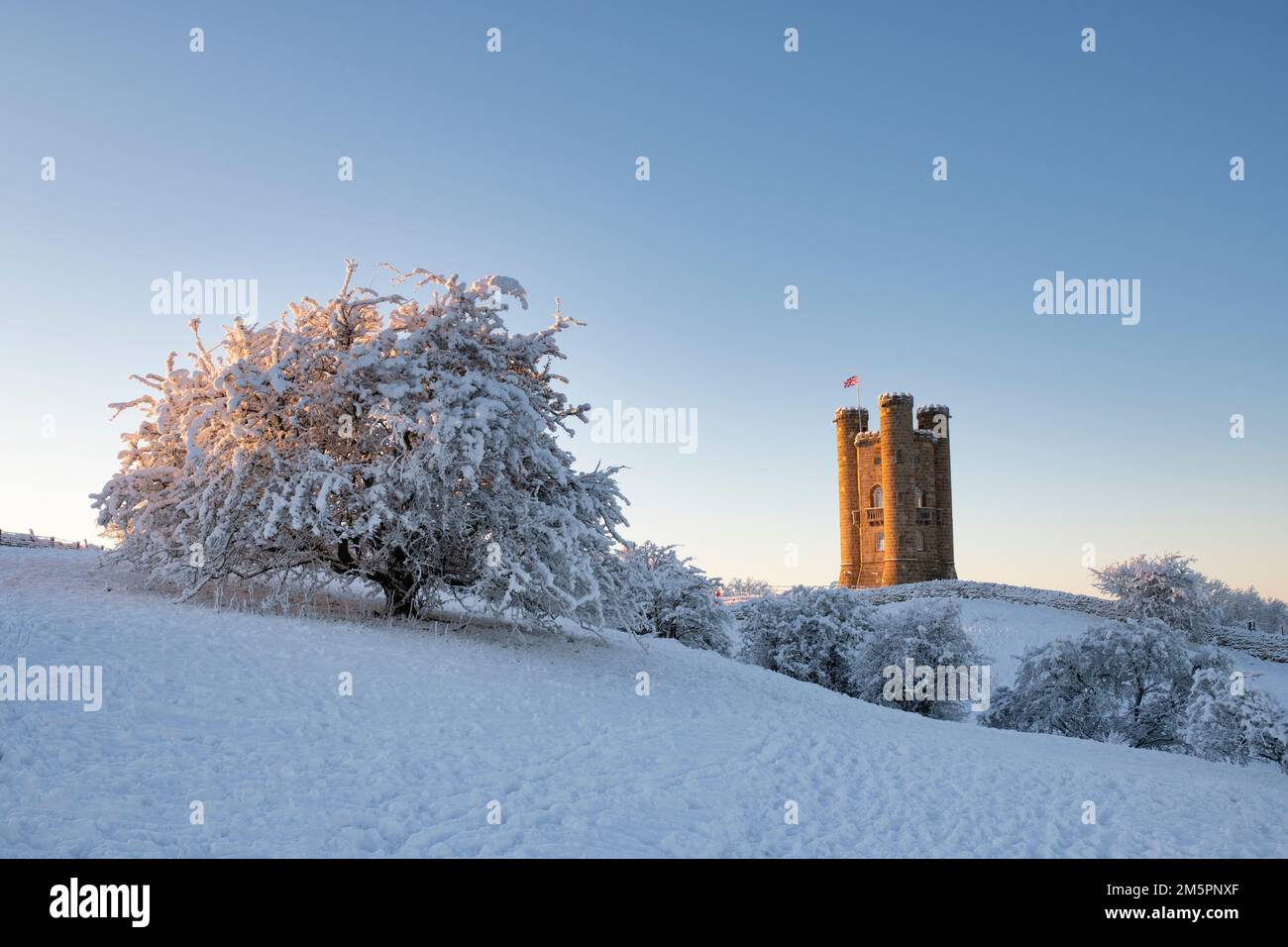 Broadway Tower bei Sonnenaufgang im Schnee entlang der cotswold Way. Broadway, Cotswolds, Worcestershire, England Stockfoto