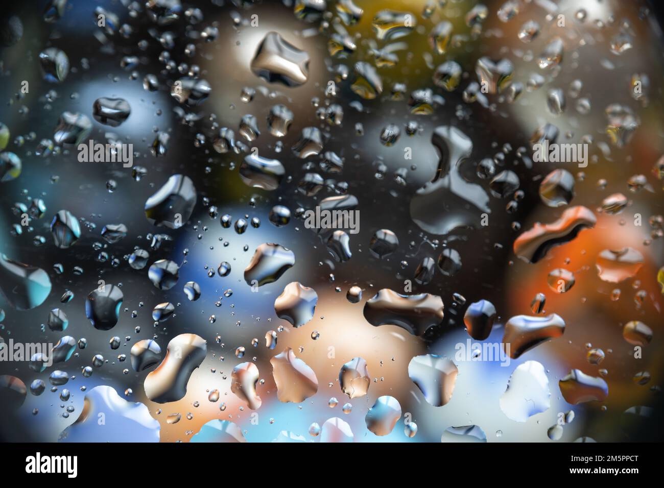 Wunderschöne Wassertropfen auf Glas mit farbigem Hintergrund, geeignet als Hintergrund oder Überlagerung Stockfoto