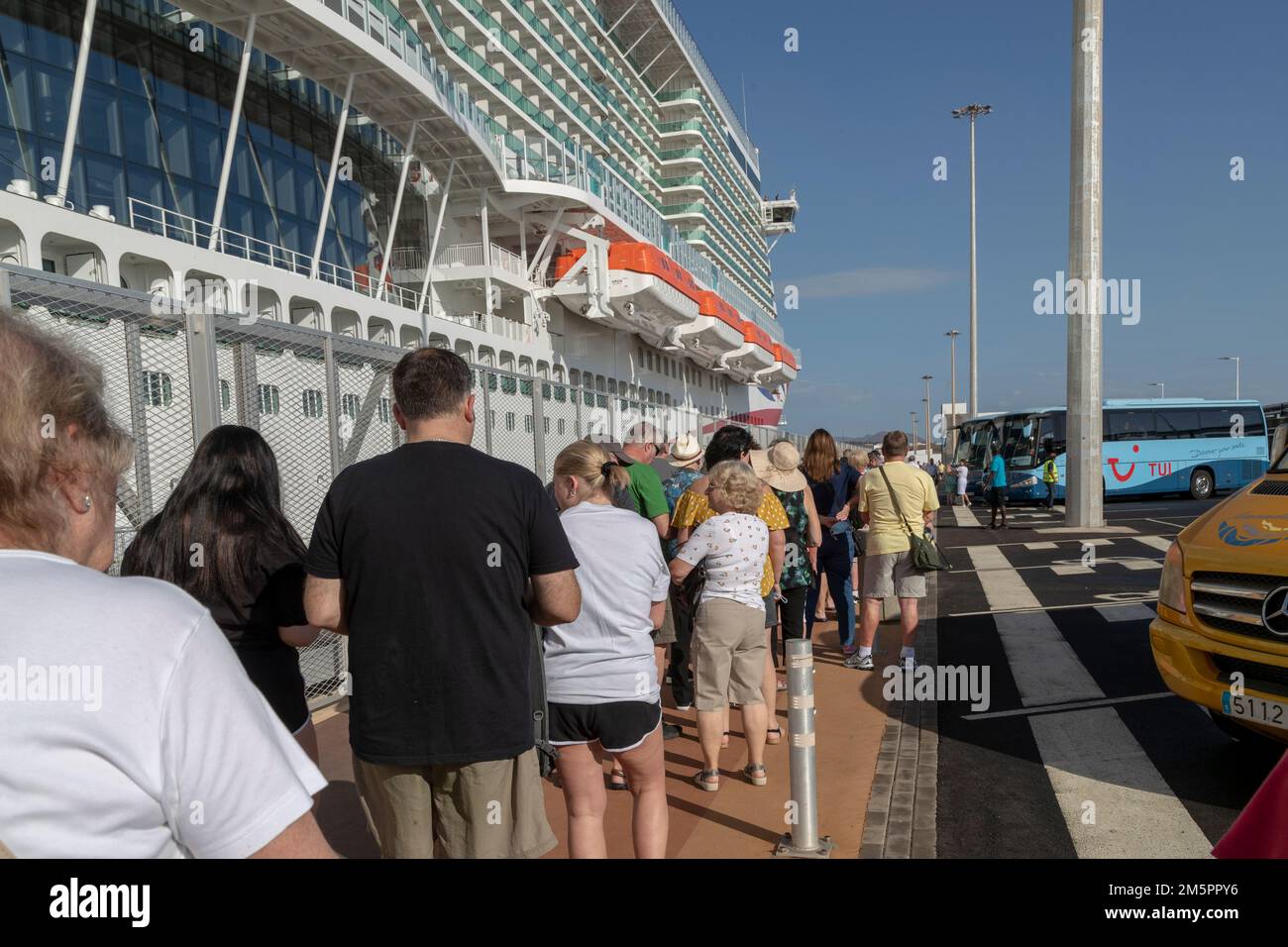 30. Dezember 2022 P&O's neuestes Schiff the180.000 Tonnen Arvia in Arrecife de Lanzarote, Spanien, lange Schlangen in der Sonne für den Shuttlebus, der Passagiere zum und vom Schiff bringt. Kredit: Keith J. Smith./Alamy Live News Stockfoto