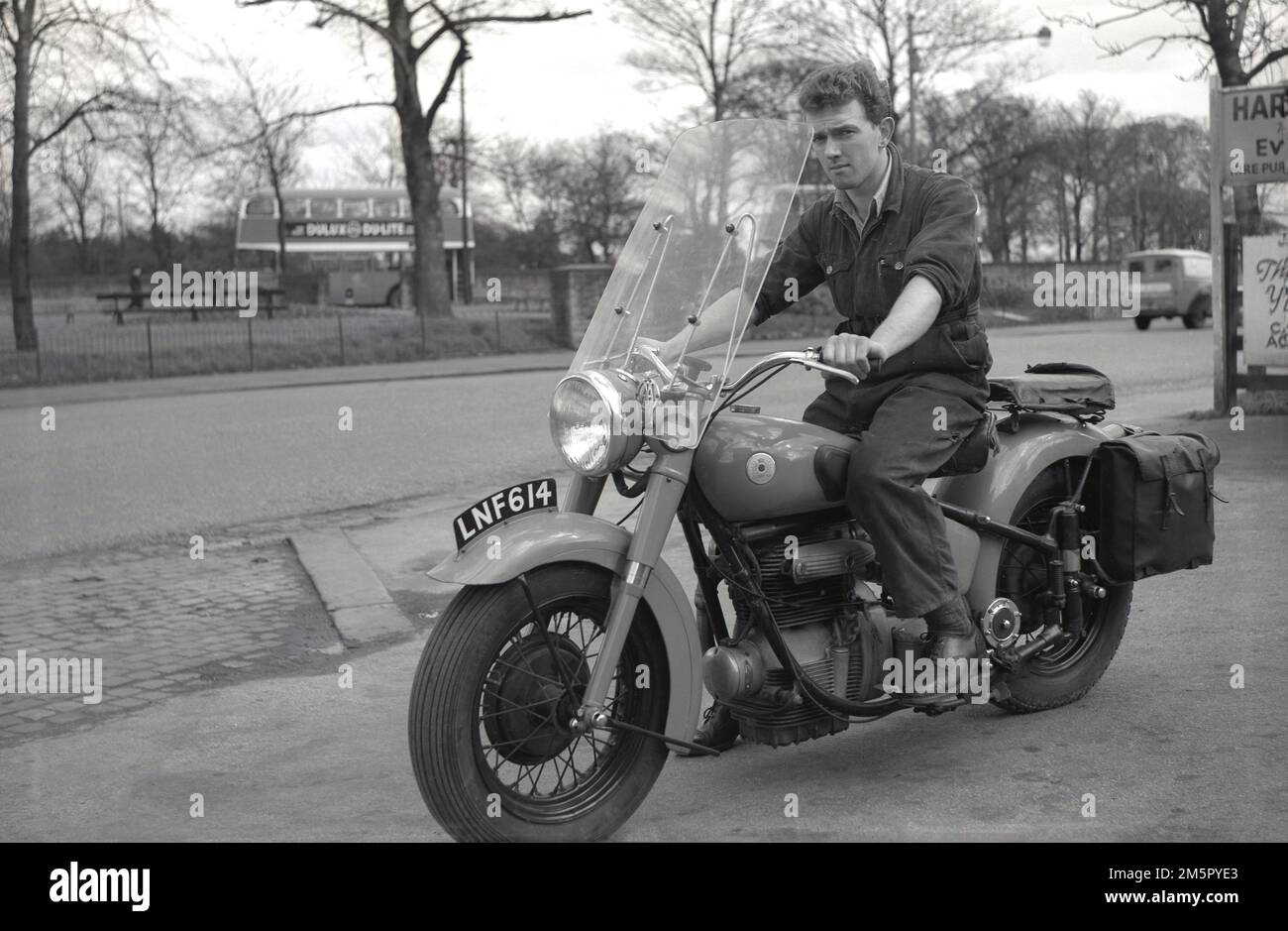 1950er Jahre, historisch, ein junger Mann, Ende 20, ein Automechaniker, in seinen Arbeitsanzügen, draußen auf seinem Sunbeam Motorrad sitzend, mit Faring, Rücksitz und panier, Hargood, Didsbury, England, Großbritannien. John Marston wurde 1887 als hochkarätiger Fahrradhersteller in Wolverhampton gegründet und begann 1912 mit der Produktion von Motorrädern, die unter verschiedenen Eigentümern wie AMC und BSA bis 1956 fortgeführt wurden. Stockfoto