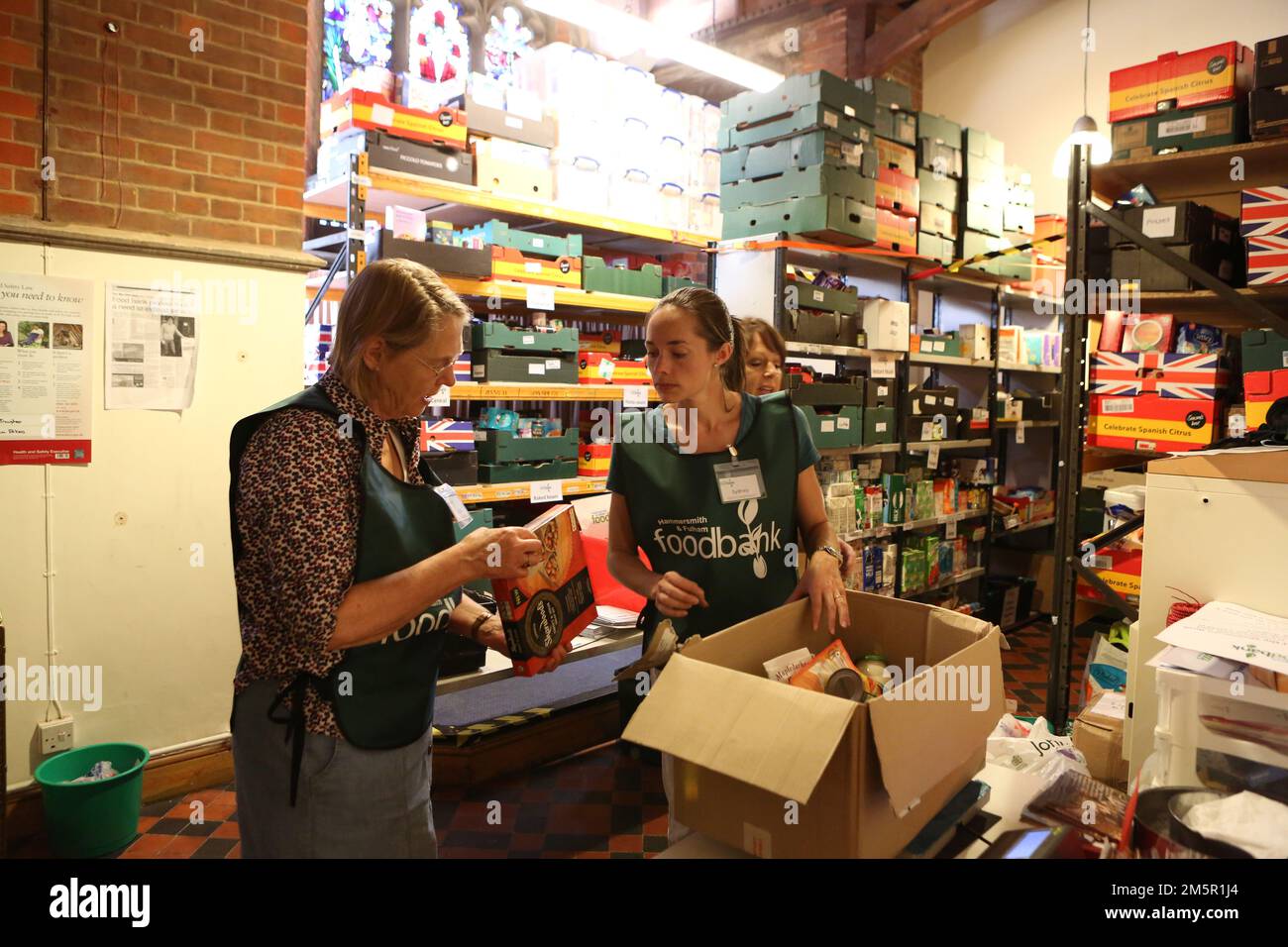 Die Foodbank in der Christ Church in Fulham. Hier bereiten die Freiwilligen Sydney Yoshida, Karen Holmes und Dora Rickford Essenspakete im Food Sto zu Stockfoto