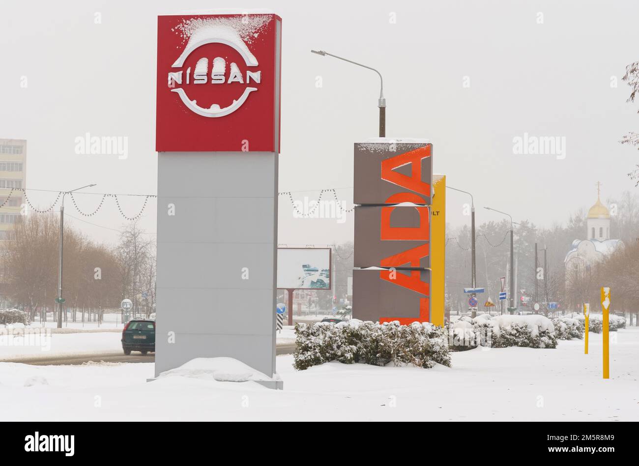 Bobruisk, Belarus, 17. Dezember 2022: Nissan Motor Corporation und Lada Plakate in der Nähe von Autohäusern Stockfoto
