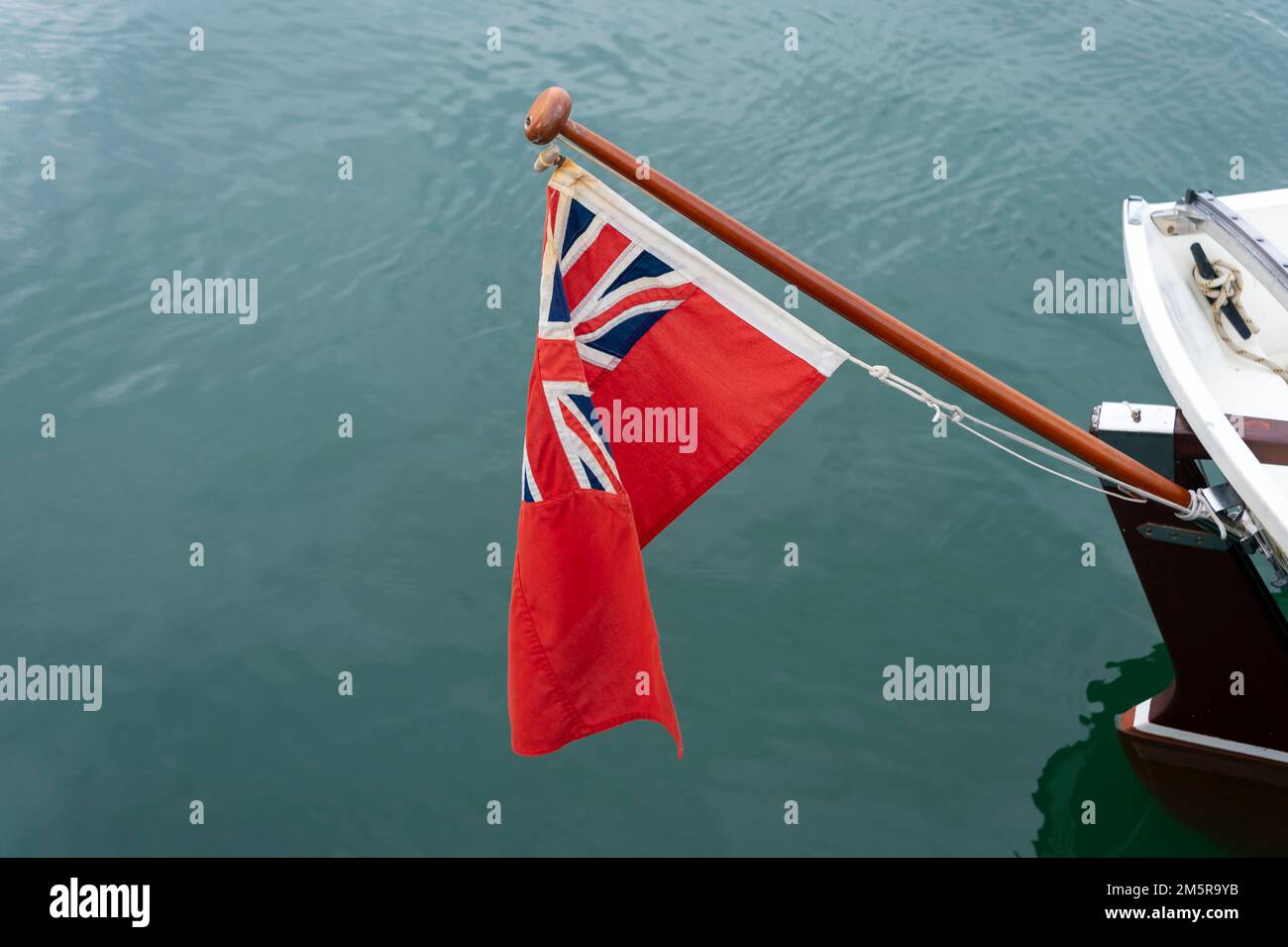 Rote Fähnrich-Flagge auf dem Heck eines Segelboots. Stockfoto