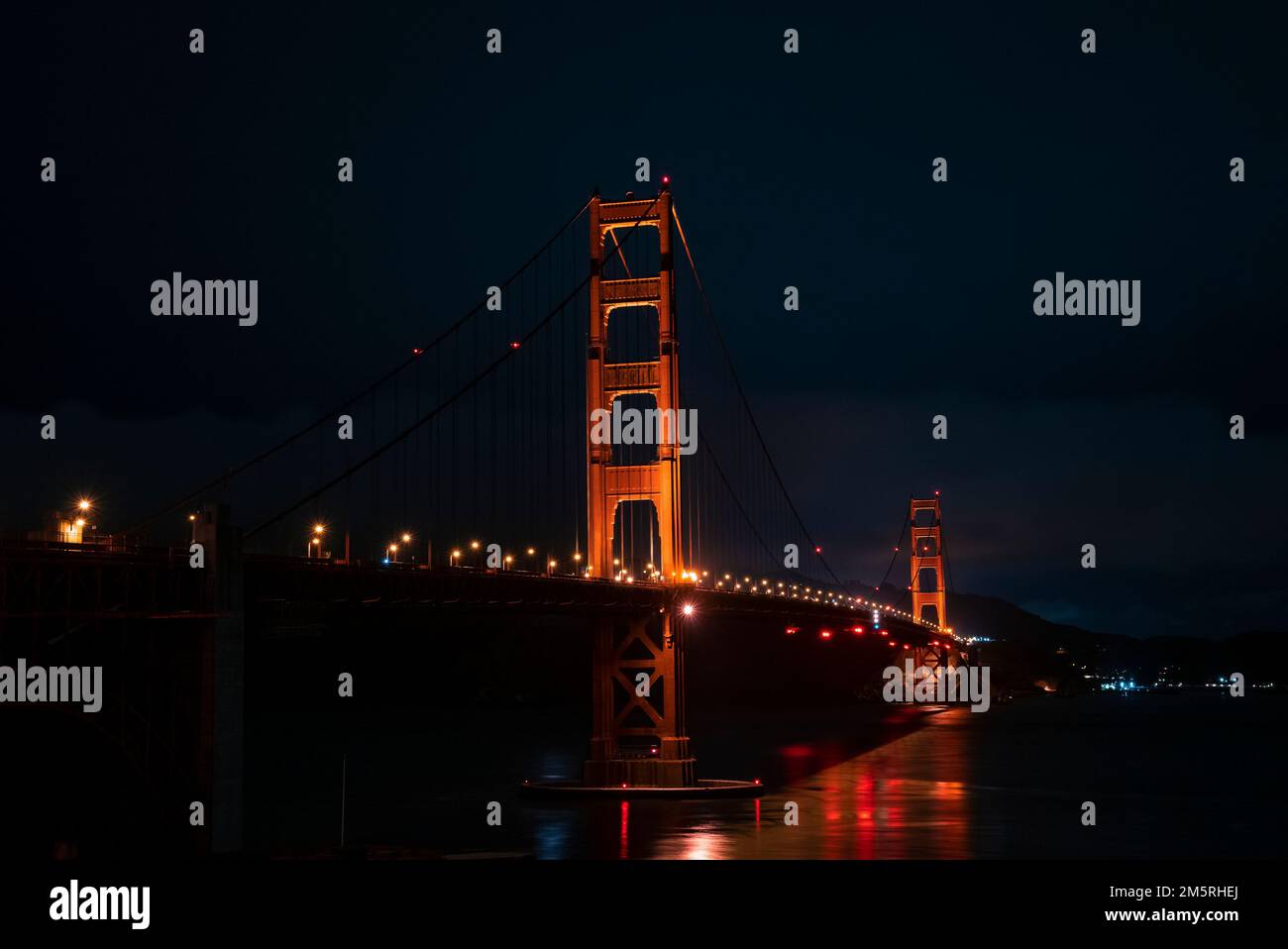 Beleuchtete Golden Gate Bridge über der Bucht von San Francisco bei Nacht Stockfoto