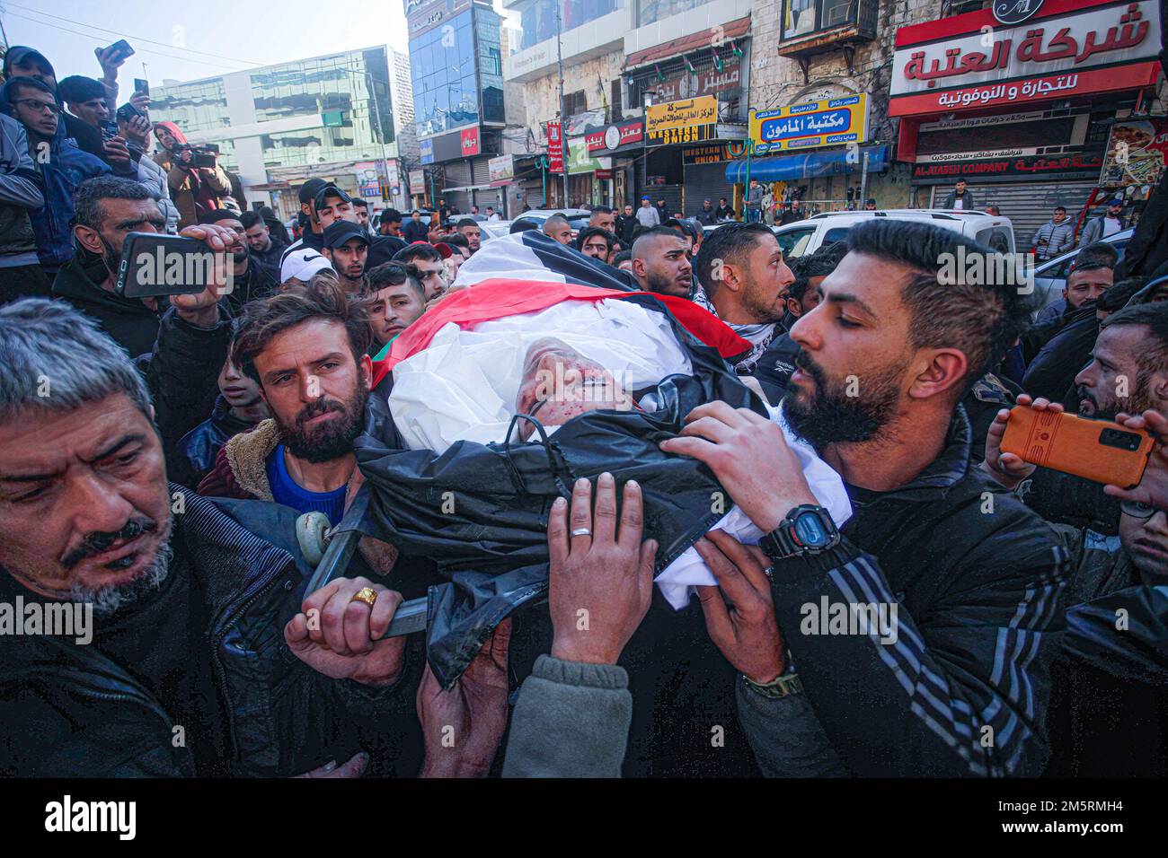 Nablus, Palästina. 30. Dezember 2022. (ANMERKUNG DER SCHRIFTLEITUNG: Bild zeigt den Tod)Palästinensische Trauer tragen die Leiche von Ammar Adili während seiner Beerdigung in der Stadt Nablus im Westjordanland. Adili wurde am 2. Dezember von einem israelischen Grenzpolizisten in der Stadt Hawara im Westjordanland getötet. Die Palästinenser sagten, dass der Offizier Adili ohne Grund tötete, indem er ihn viermal aus nächster Nähe erschoss, in einem Vorfall, der auf einem weit verbreiteten Video aufgezeichnet wurde. Die israelische Polizei sagt, Adili wurde in Notwehr erschossen, nachdem er Israelis angegriffen hat. Die Armee ließ seine Leiche am Freitag frei. Kredit: SOPA Images Limited/Alamy Live News Stockfoto