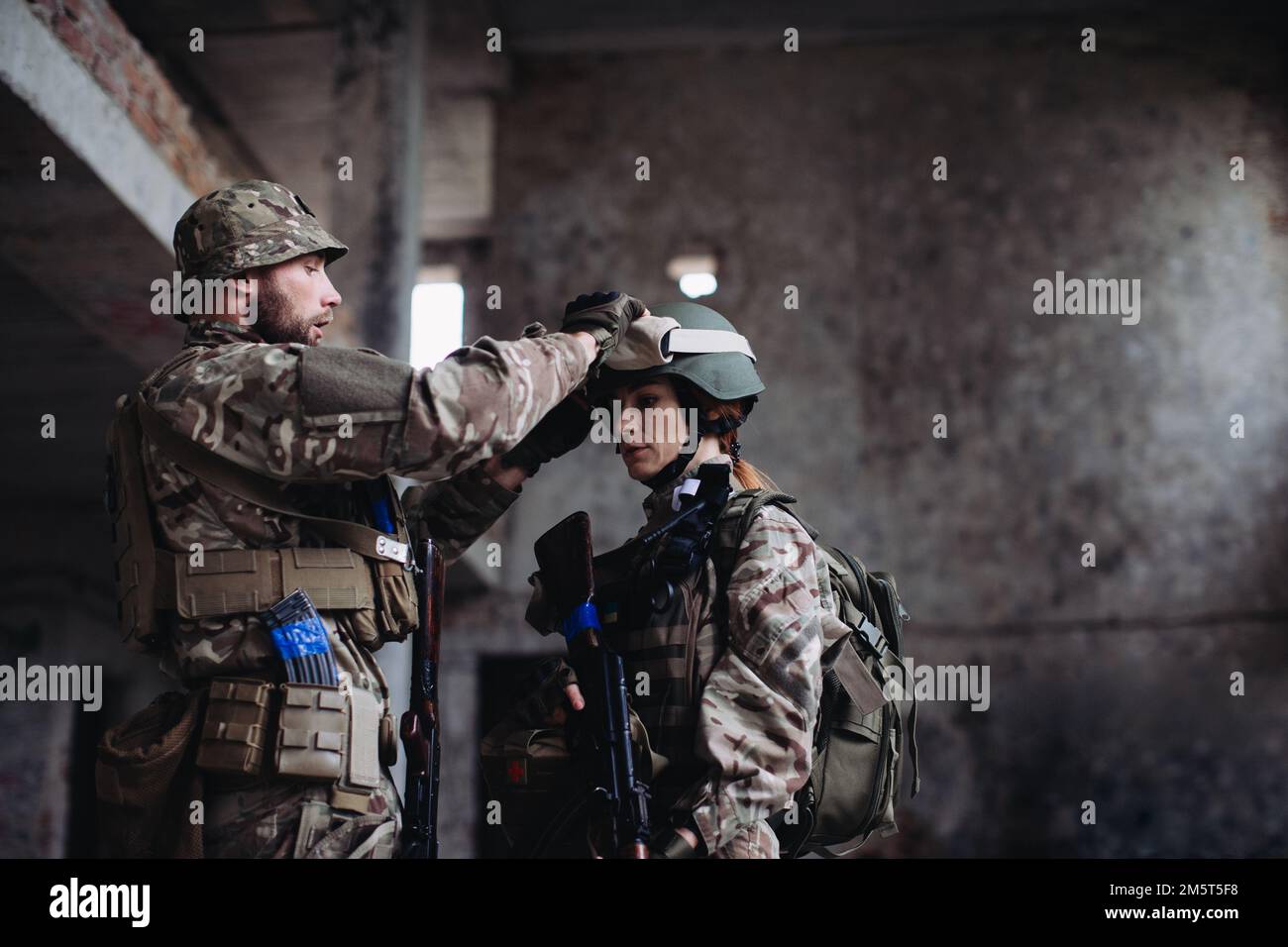 Voll ausgestattete und bewaffnete ukrainische Soldaten überprüfen ihre Ausrüstung während einer Pause. Stockfoto