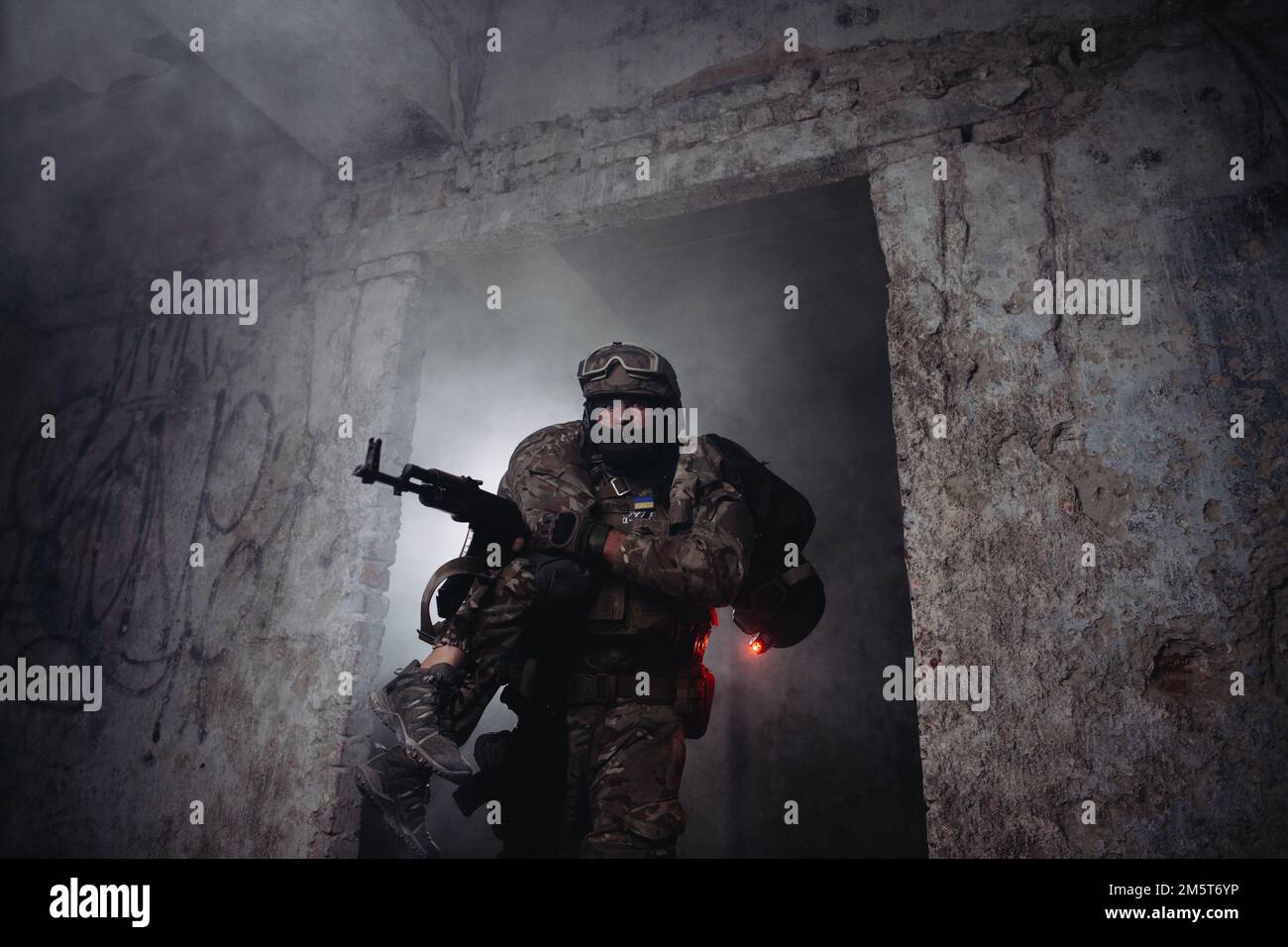 Evakuierung eines verwundeten Soldaten. Ein Soldat trägt seinen verwundeten Bruder in Waffen vom Schlachtfeld. Stockfoto