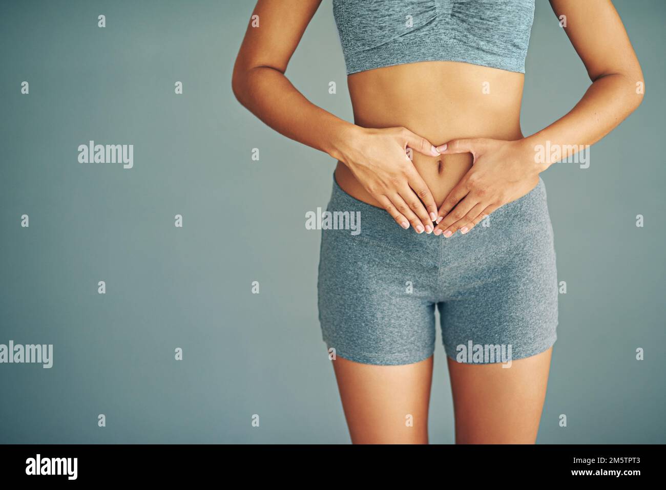 Ich habe die Kontrolle. Eine junge Frau, die ein Herz auf dem Bauch bildet. Stockfoto