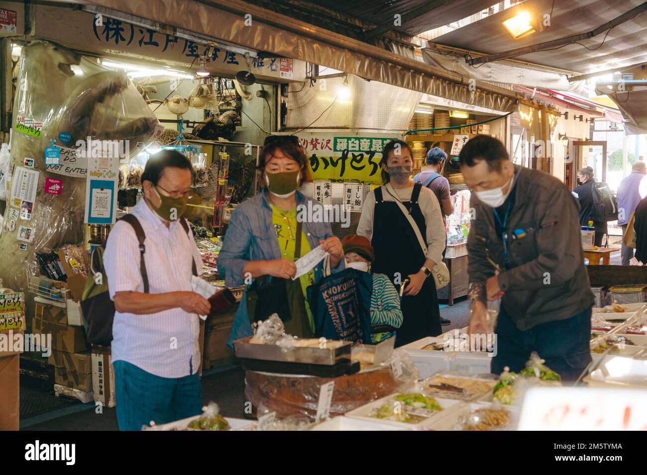 Kunden, die Lebensmittel auf dem Tsukiji-Markt kaufen Stockfoto