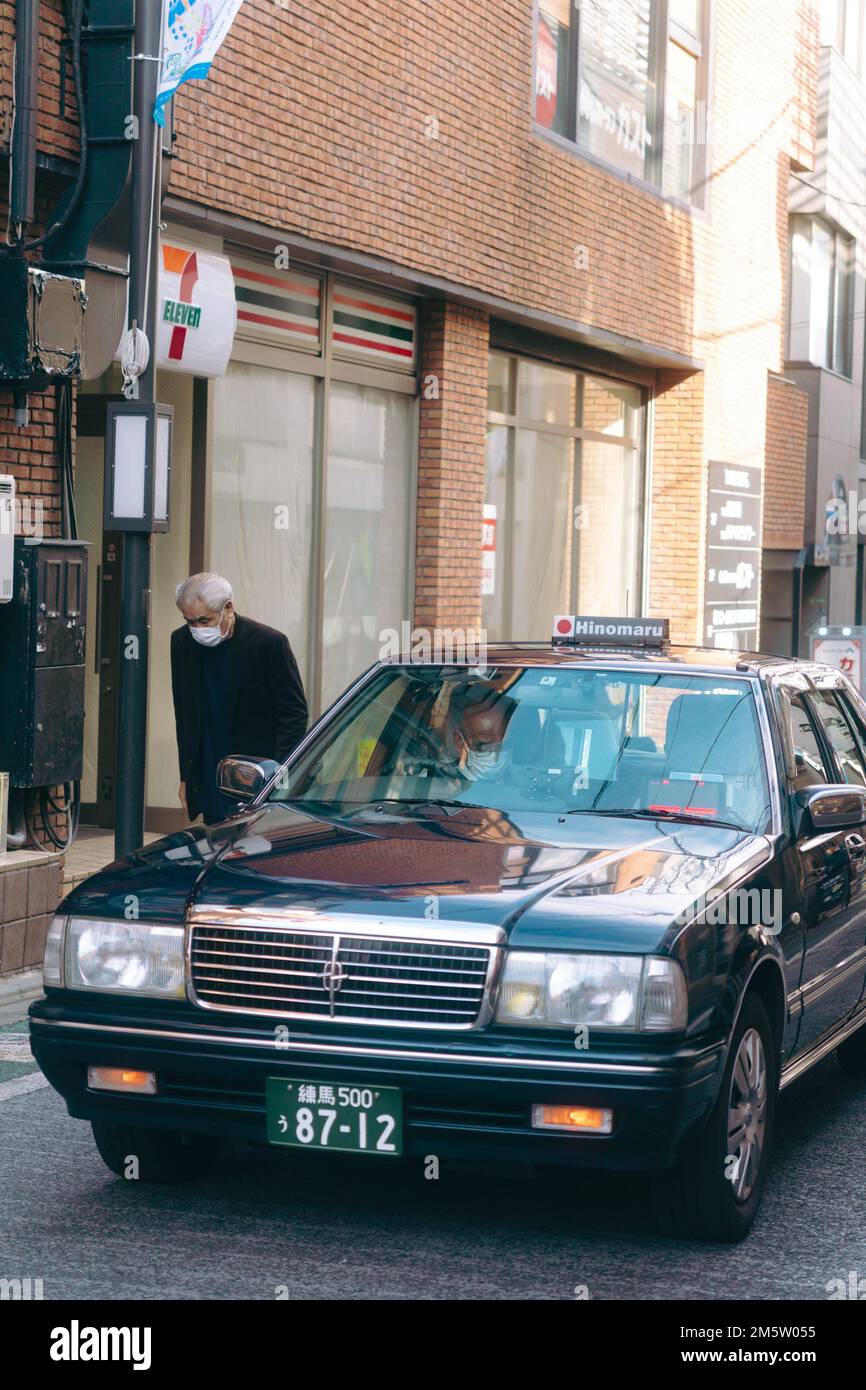 Ein Taxifahrer, der in der Innenstadt von Tokio arbeitet Stockfoto