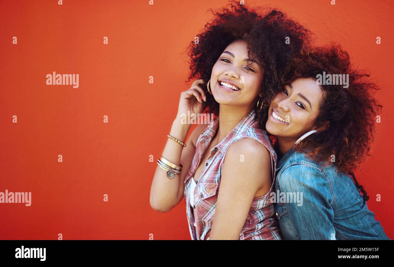 Beste Freunde werden immer füreinander da sein. Zwei junge Freunde, die vor rotem Hintergrund posieren. Stockfoto