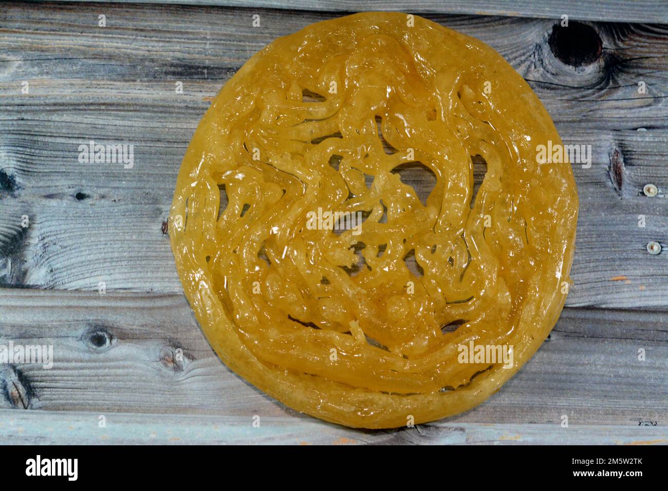 Ägyptischer Meshabek, ein abgerundeter Süßstoff aus frittiertem knusprigem Teig, der entweder in Honig oder Zuckersirup getränkt ist. Der Name wird in (verdreht) übersetzt. Stockfoto