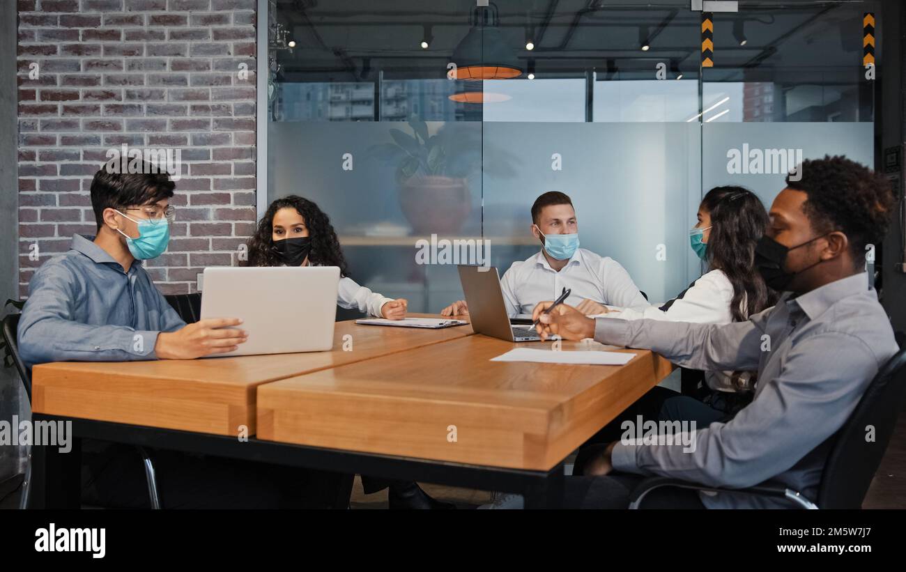 Vielfältiges Business Team Mitarbeiter in medizinischen Masken zusammenarbeiten im Büro multiethnische Kollegen multiethnische Gruppen Teamarbeit über Projekt diskutieren Stockfoto