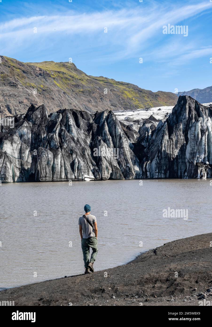 Tourist am Seeufer einer Gletscherlagune, Gletscherzunge mit Spalten und See, Solheimajoekull, Süd-Island, Island Stockfoto