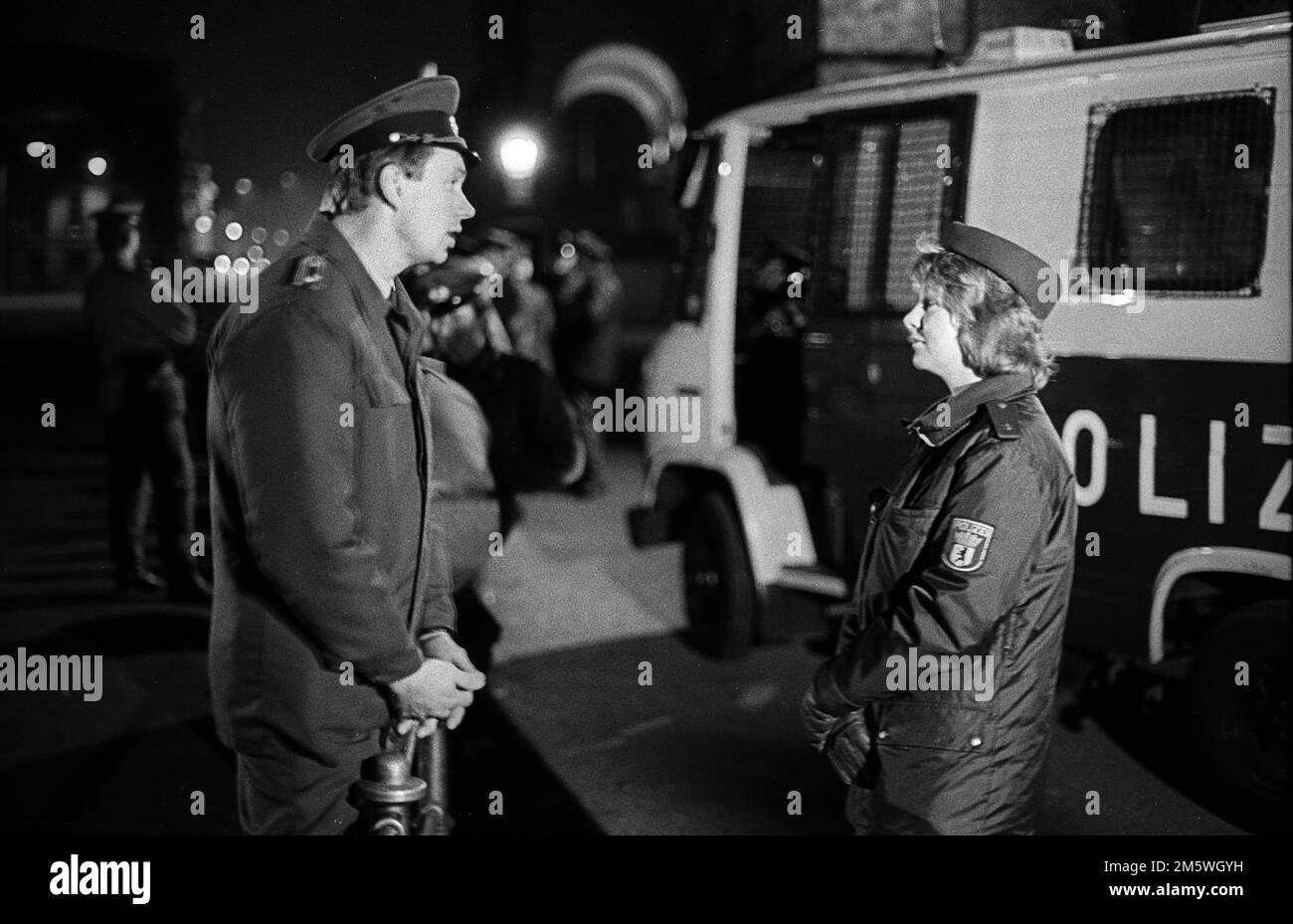 DDR, Berlin, 21. 02. 1990, Abriss der Mauer am Reichstag, ein Volkspolizist und eine Polizistin aus dem Westen im Gespräch. . (Abriss von Stockfoto