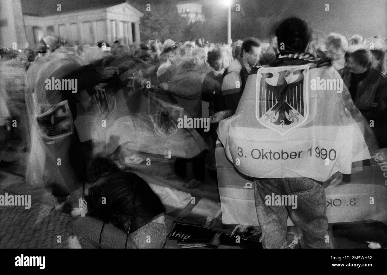 DDR, Berlin, 02. 10. 1990. Feier der Wiedervereinigung am Abend des 2. Oktober am Brandenburger Tor, Flaggen Stockfoto