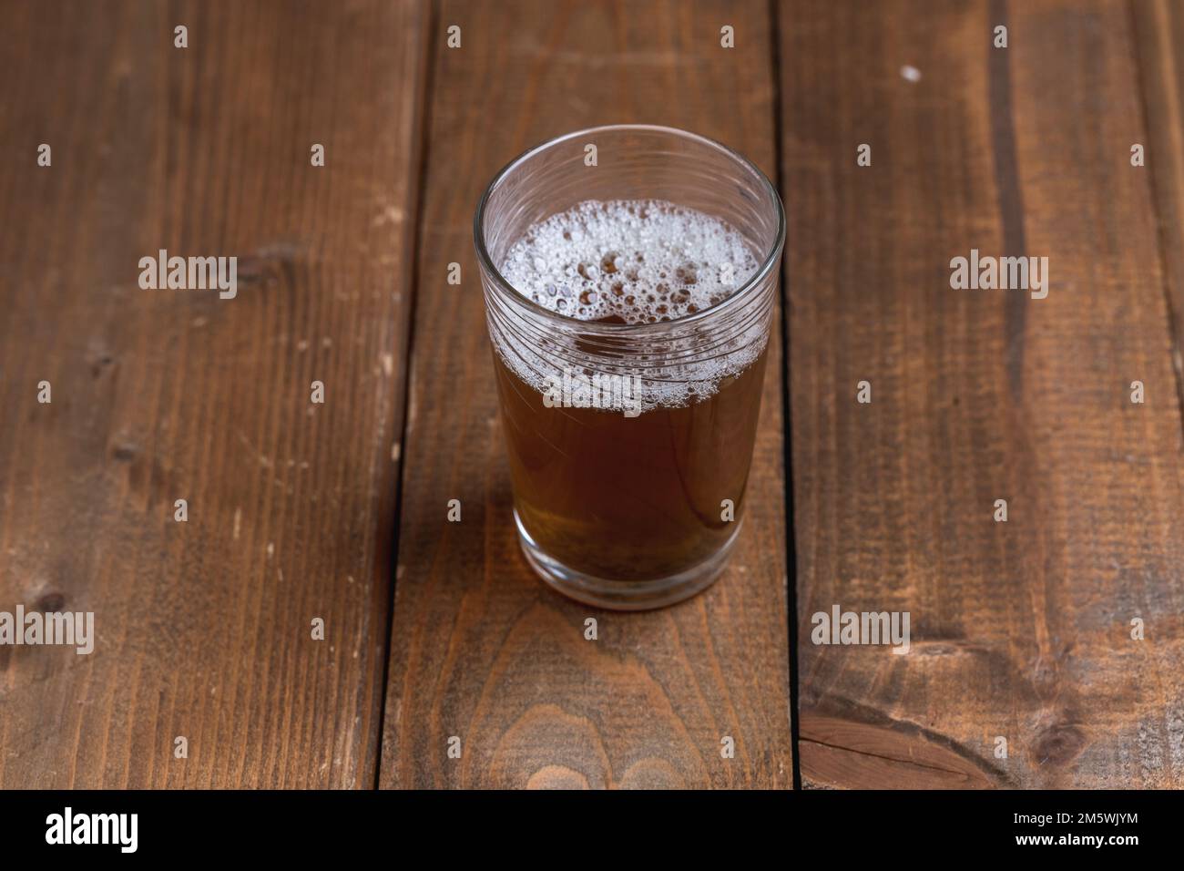 Glas Tee mit Schaum auf einem rustikalen Holztisch. Erfrischung, Pause, Getränk. Stockfoto