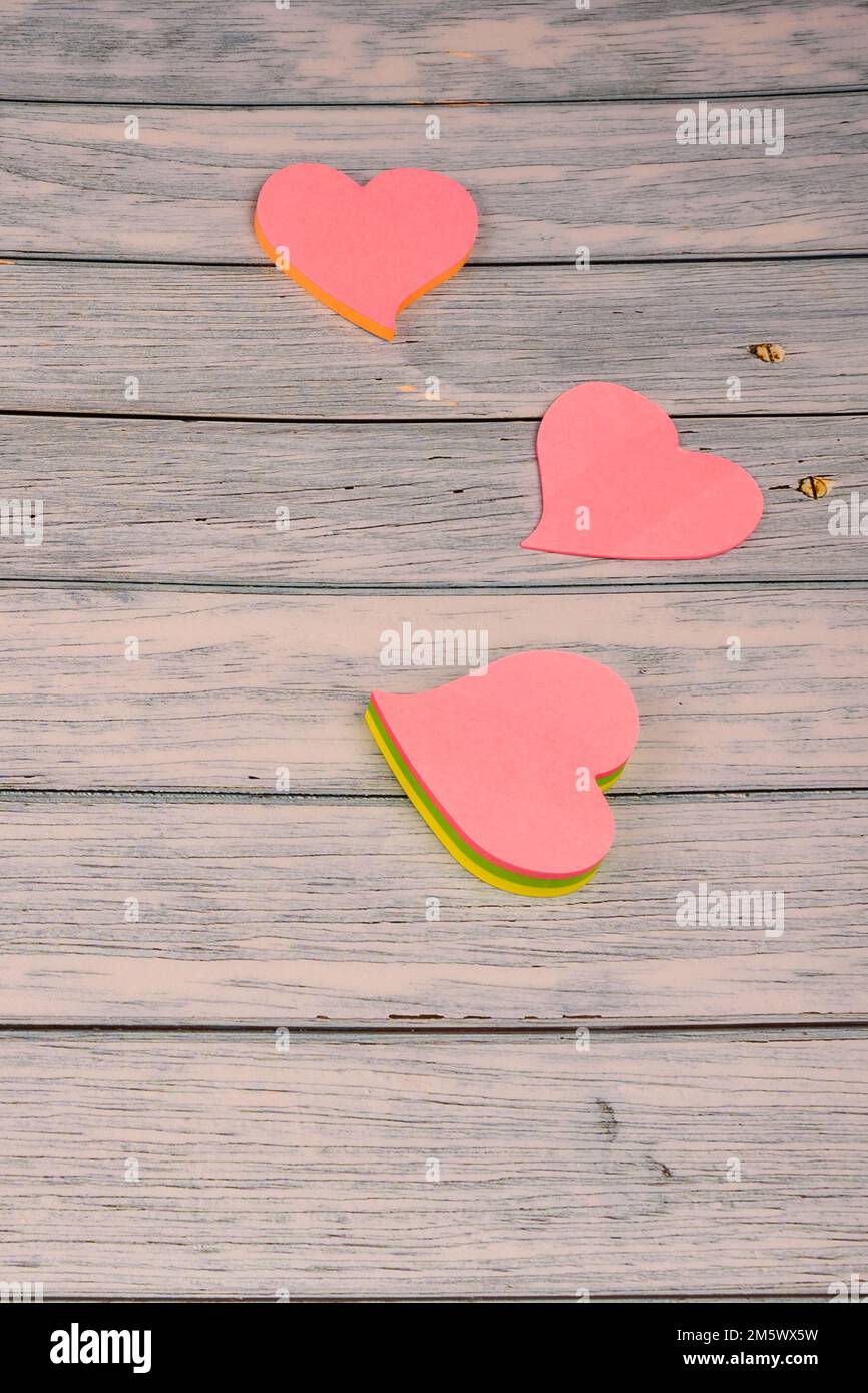 Drei rosa Herzen auf einem Holztisch. Stockfoto