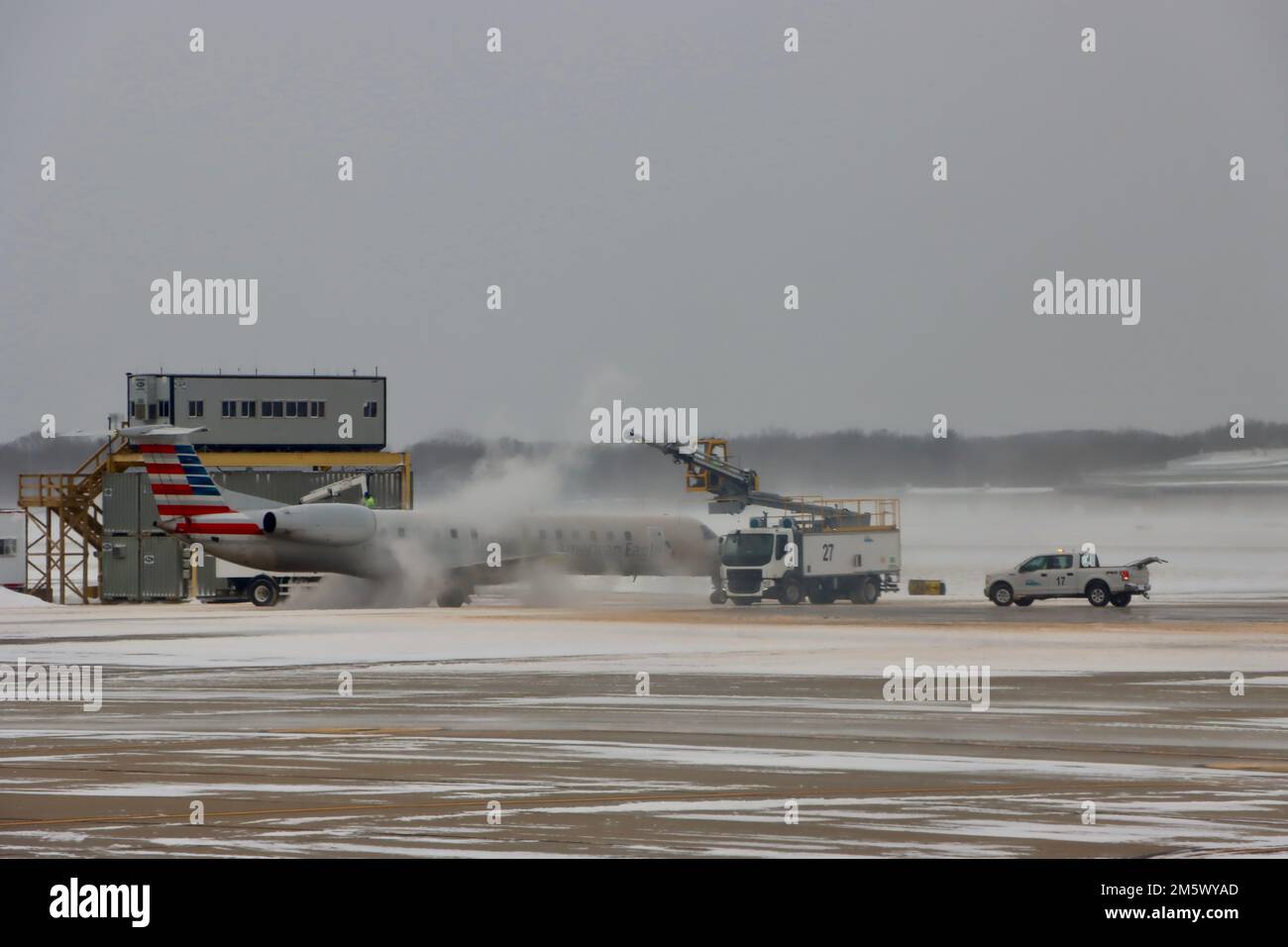 Am 24 2022. Dezember nach einem Schneesturm startete am Flughafen Cleveland Hopkins ein Deicing American Airlines-Kleinjet. Stockfoto