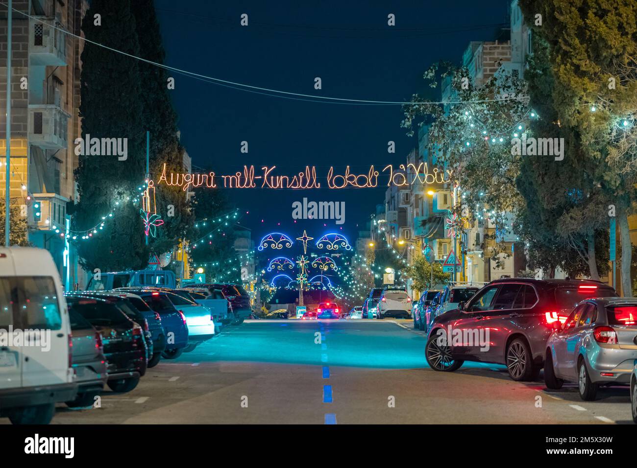 Road in sliema, malta, wo weihnachten „Happy holidays“ auf der anderen Straßenseite schreibt und andere weihnachtsdekorationen. Stockfoto