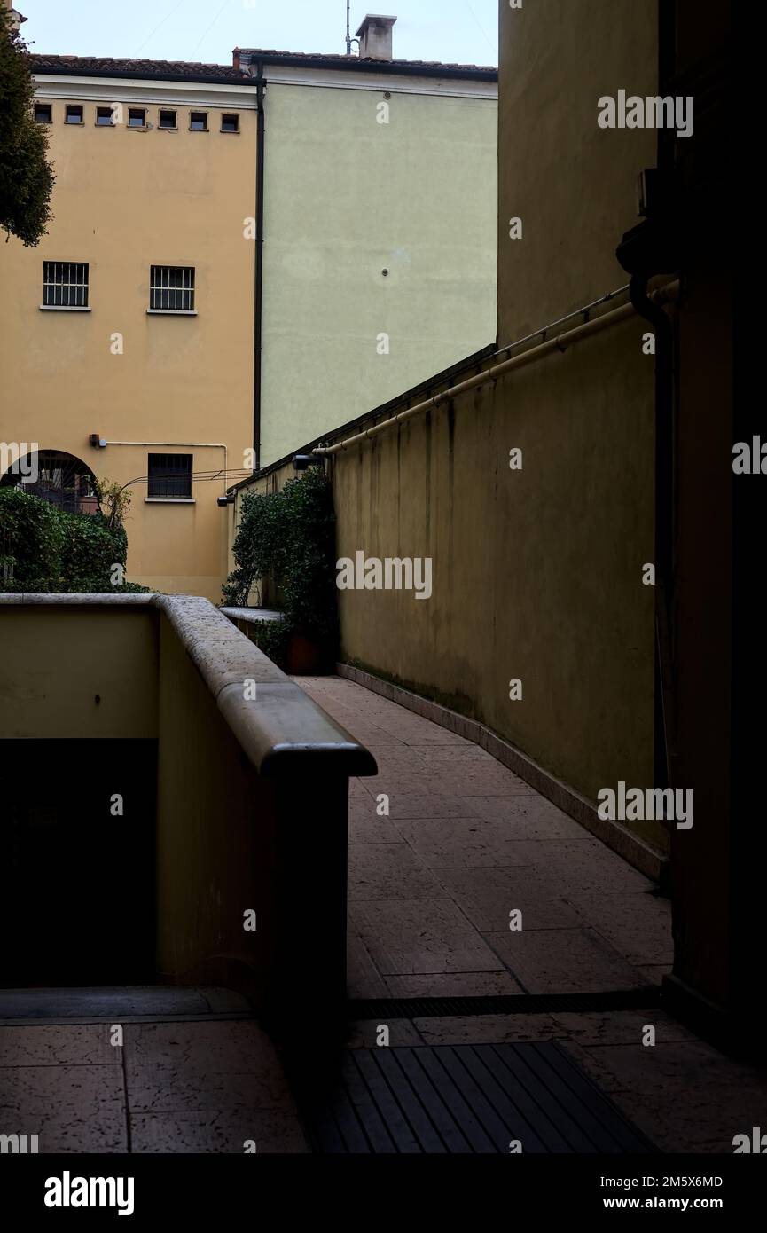 Straßenbelag auf einem Hof und absteigender Weg zu einer Garage im Schatten Stockfoto