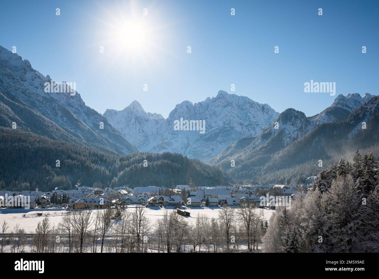 Kranjska Gora in Slowenien im Winter mit Schnee bedeckt, mit den Julianischen Alpen und dem Triglav-Nationalpark im Hintergrund Stockfoto