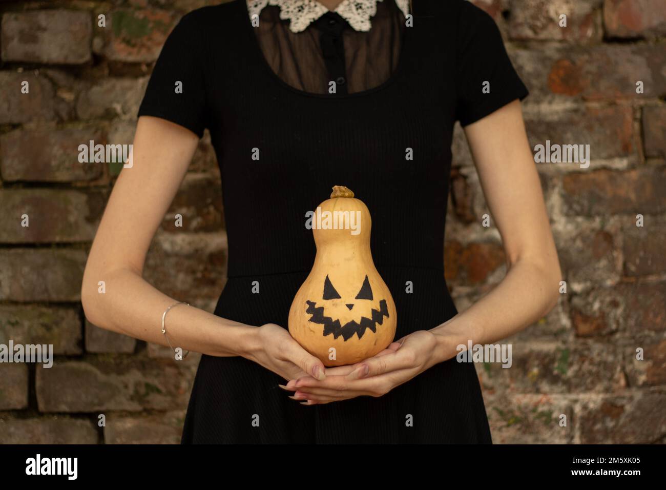 Kürbis in den Händen eines Mädchens, gemalt für halloween, halloween-Feiertag in der ukraine Stockfoto