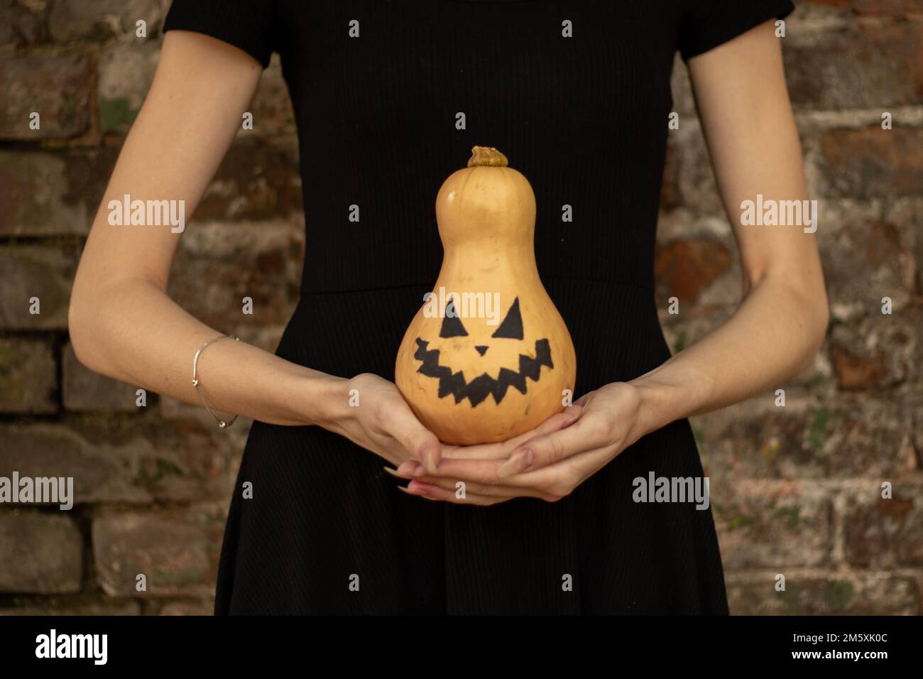 Kürbis in den Händen eines Mädchens, gemalt für halloween, halloween-Feiertag in der ukraine Stockfoto
