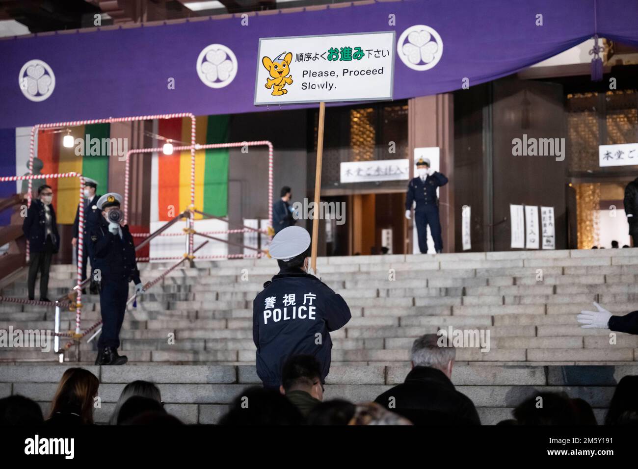 Tokio, Japan. 1. Januar 2023. Die Tokyo Metropolitan Police behält die Kontrolle über die Menge, während Neujahrsfeierlichkeiten im Jahr 2023 im Zojo-ji-Tempel, einem großen buddhistischen Tempel, der 1393 in Minato City in Tokio gegründet wurde, das neue Jahr feiern. Japan mit dem Tokyo Tower im Hintergrund.Japan hat sich nach über zwei Jahren Reiseverboten aufgrund der COVID-19-Pandemie vor kurzem wieder für den Tourismus geöffnet. Der Yen hat gegenüber dem US-Dollar stark abgeschrieben, was zu wirtschaftlichen Turbulenzen für den internationalen Handel und die japanische Wirtschaft geführt hat. Kredit: ZUMA Press, Inc./Alamy Live News Stockfoto