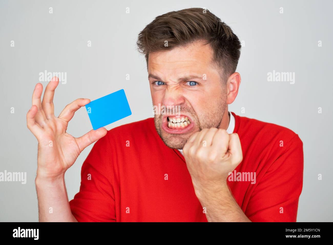 Ein Mann, der sich traurig, aufgebracht oder wütend fühlt, mit einer Kreditkarte nicht einverstanden ist. Stockfoto