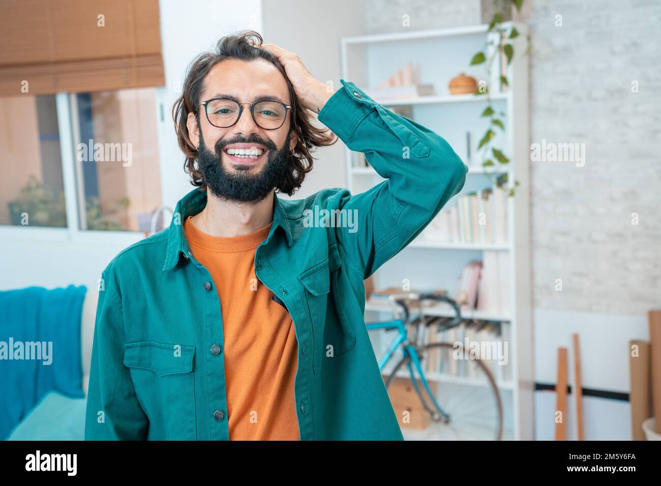 Junger kreativer Unternehmer, der im modernen Home Office vor der Kamera lächelt Stockfoto