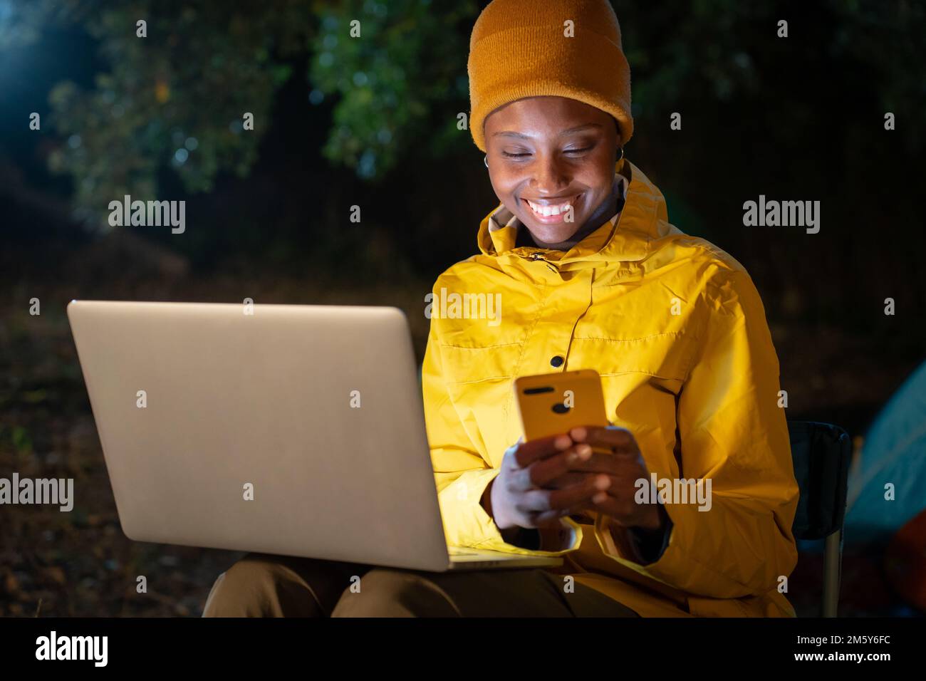 Eine Frau arbeitet abends an einem Notebook in der Natur. Stockfoto