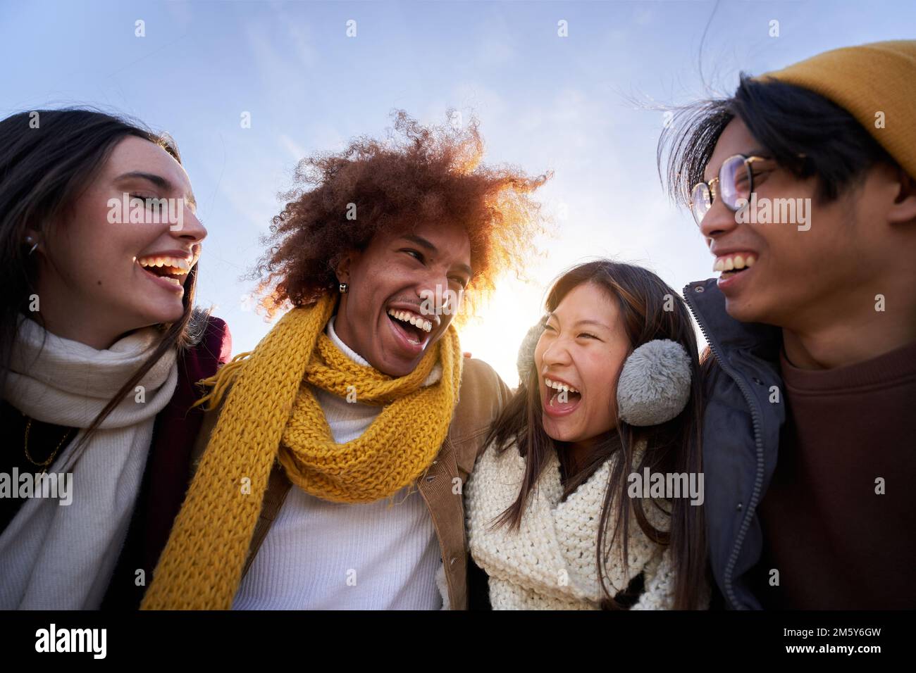 Multiethnische Gruppe von Freunden, die sich umarmen und Spaß haben isolierte junge, lächelnde Menschen, die zusammen lachen Stockfoto