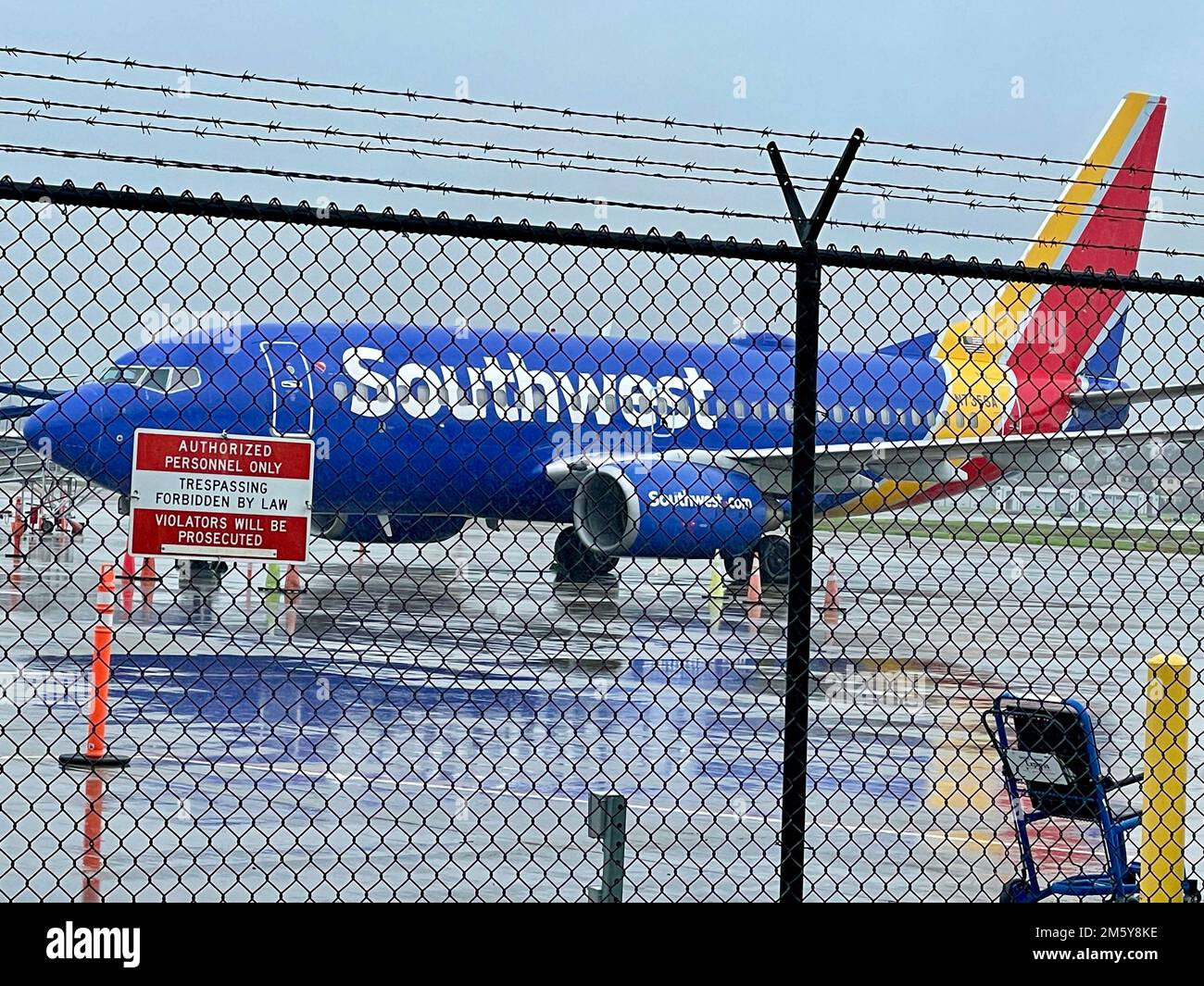 GOLETA, Kalifornien, USA 31. Dezember 2022. Southwest Airplane auf Asphalt am Santa Barbara Airport an einem regnerischen 31. Dezember 2022; ein „No Trespassing“-Schild im Vordergrund auf Stacheldraht. (Kreditbild: © Amy Katz/ZUMA Press Wire) Kredit: ZUMA Press, Inc./Alamy Live News Stockfoto