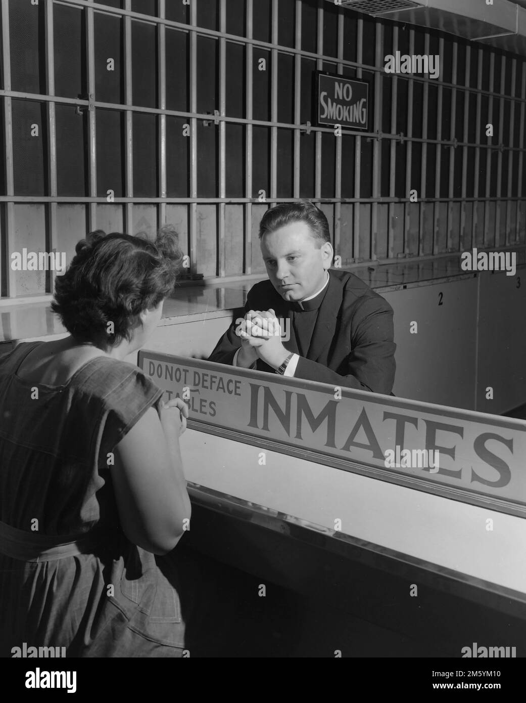 Ein Foto einer Gefangenen, die mit einem Priester in einem kalifornischen Gefängnis spricht. 1950. Stockfoto