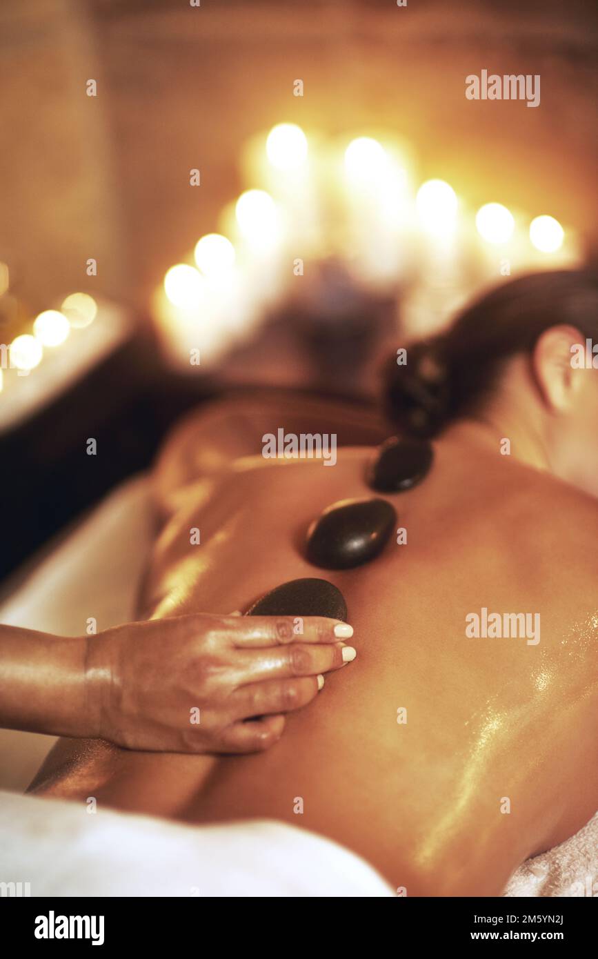 Eine Hot-Stone-Massage. Eine junge Frau, die eine Hot-Stone-Massage bekommt. Stockfoto