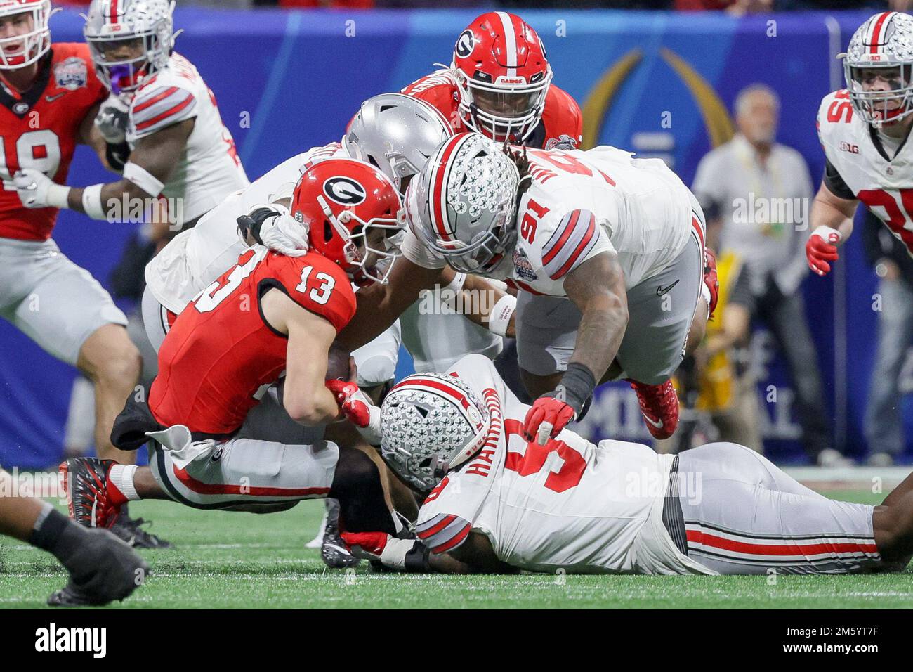 Atlanta, Georgia, USA. 31. Dezember 2022. Georgia Bulldogs Quarterback Stetson Bennett (13) wird während der Chick-fil-A Peach Bowl im Mercedes Benz Stadium, Atlanta, Georgia, von Ohio State Buckeyes Defensive Tackle Tyleik Williams (91) und Ohio State Buckeyes Defensive End Javontae Jean-Baptiste (8) gefeuert. (Kreditbild: © Scott Stuart/ZUMA Press Wire) Kredit: ZUMA Press, Inc./Alamy Live News Stockfoto