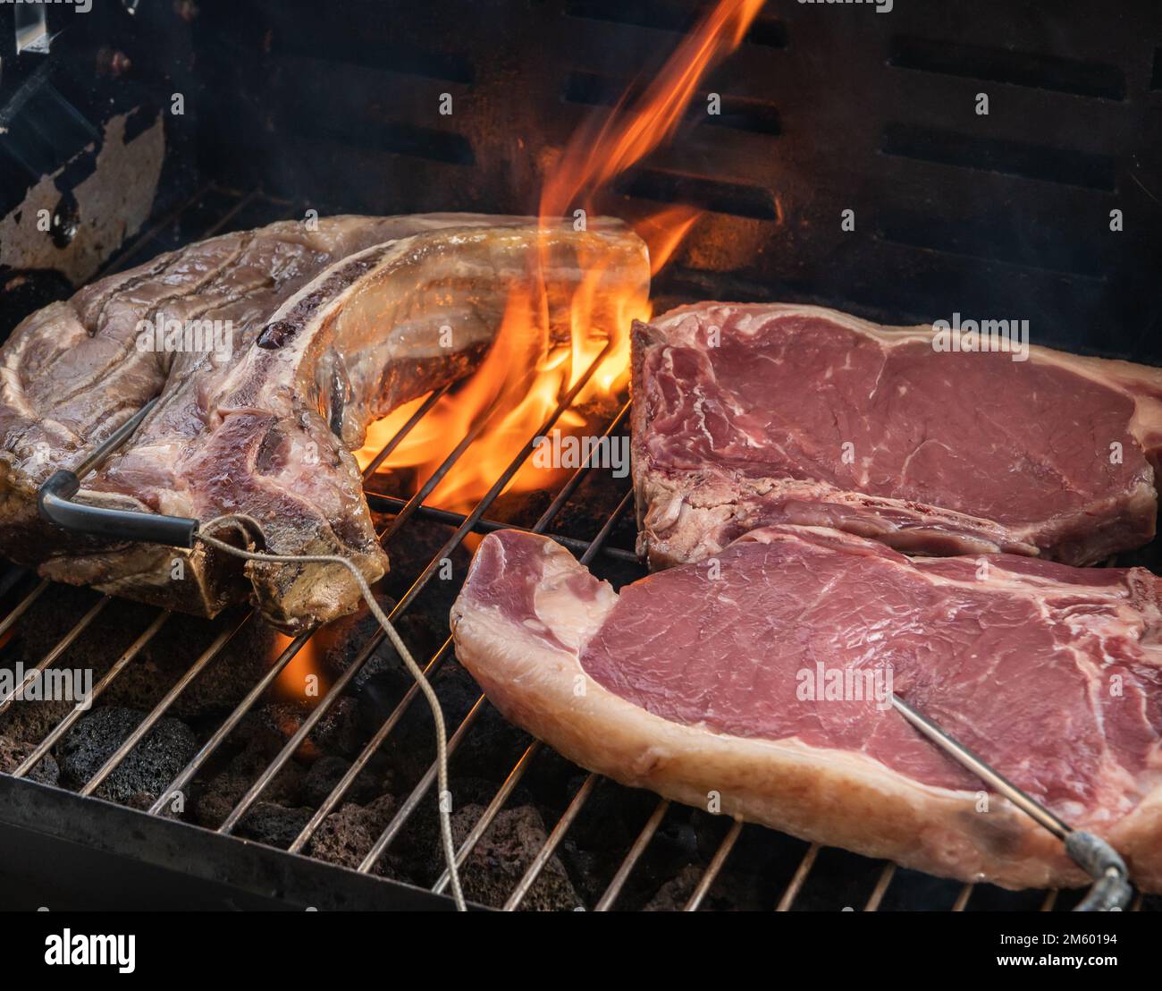 Gegrilltes T-Bone Steak (Rindersteak) auf einem Grill mit Fleischthermometer. Selektiver Fokus - Trentino Alto Adige, Norditalien - Europa Stockfoto