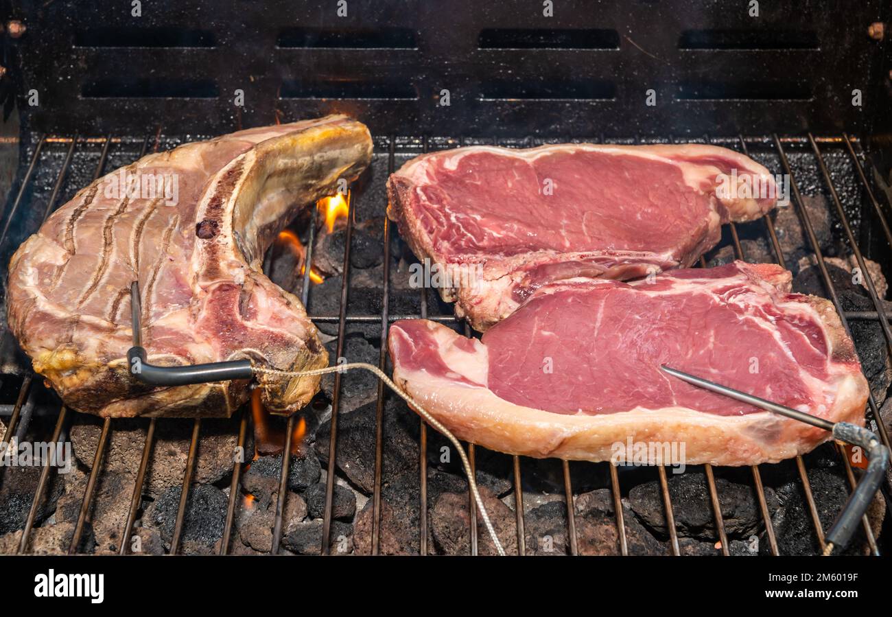 Gegrilltes T-Bone Steak (Rindersteak) auf einem Grill mit Fleischthermometer. Selektiver Fokus - Trentino Alto Adige, Norditalien - Europa Stockfoto