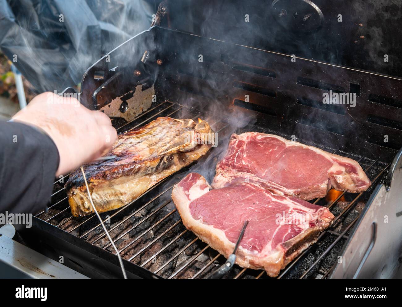 Gegrilltes T-Bone Steak (Rindersteak) auf einem Grill mit Fleischthermometer. Selektiver Fokus - Trentino Alto Adige, Norditalien - Europa Stockfoto