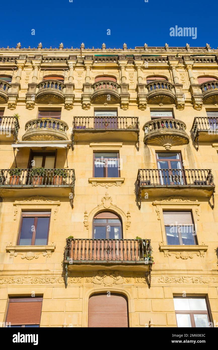 Balkone in einem gelben Apartmentgebäude in San Sebastian, Spanien Stockfoto