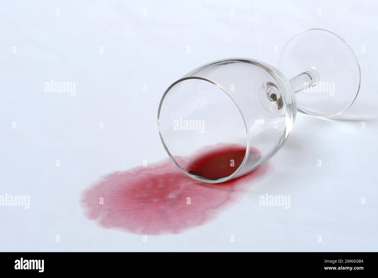 Rotweinfleck, umgedrehtes Rotweinglas auf Stoff, Fleck Stockfoto