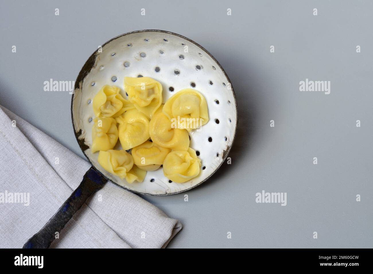 Cappelletti, gekochte Pasta in einer Siebkelle, Pasta Stockfoto