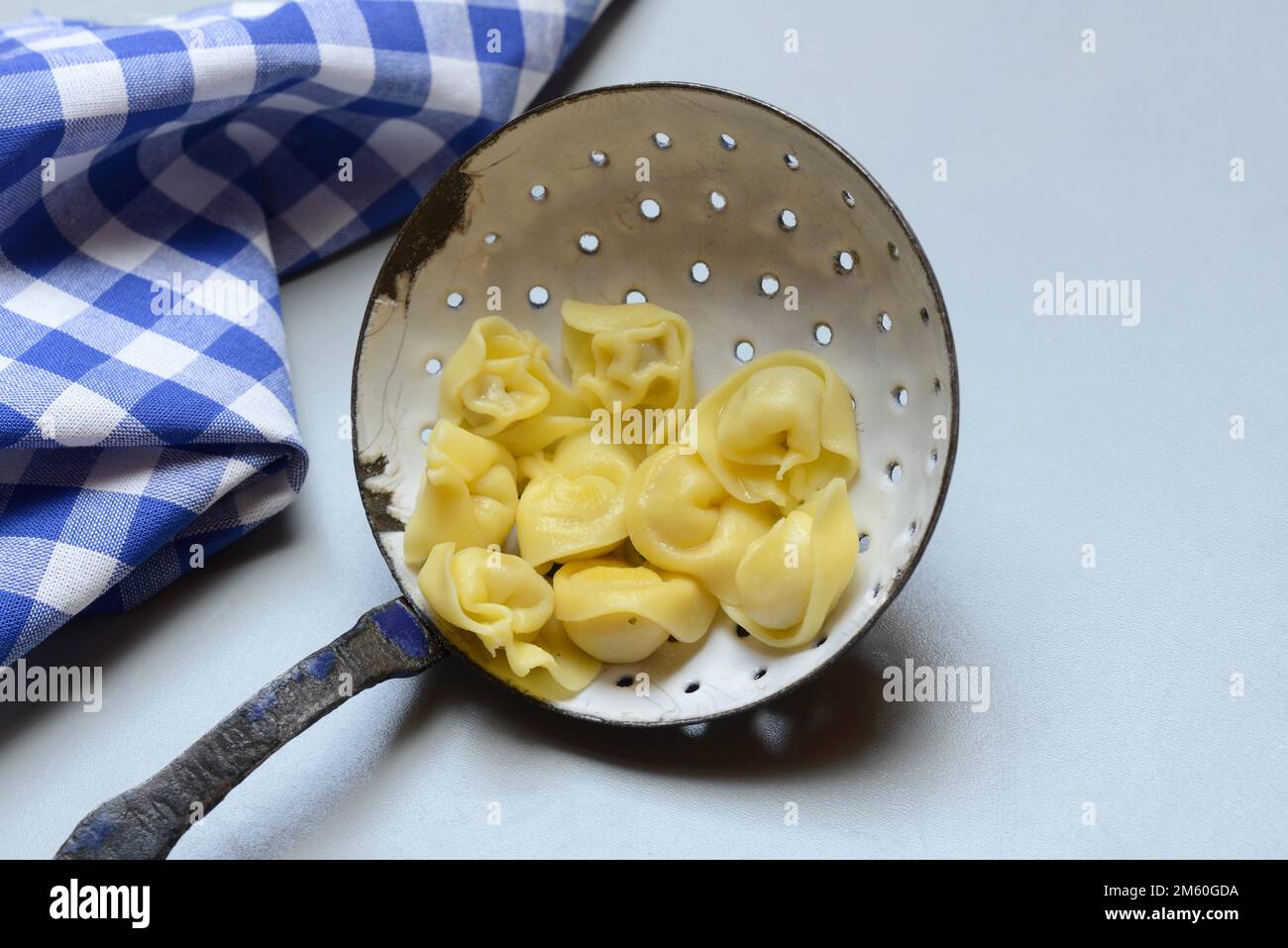 Cappelletti, gekochte Pasta in einer Siebkelle, Pasta Stockfoto