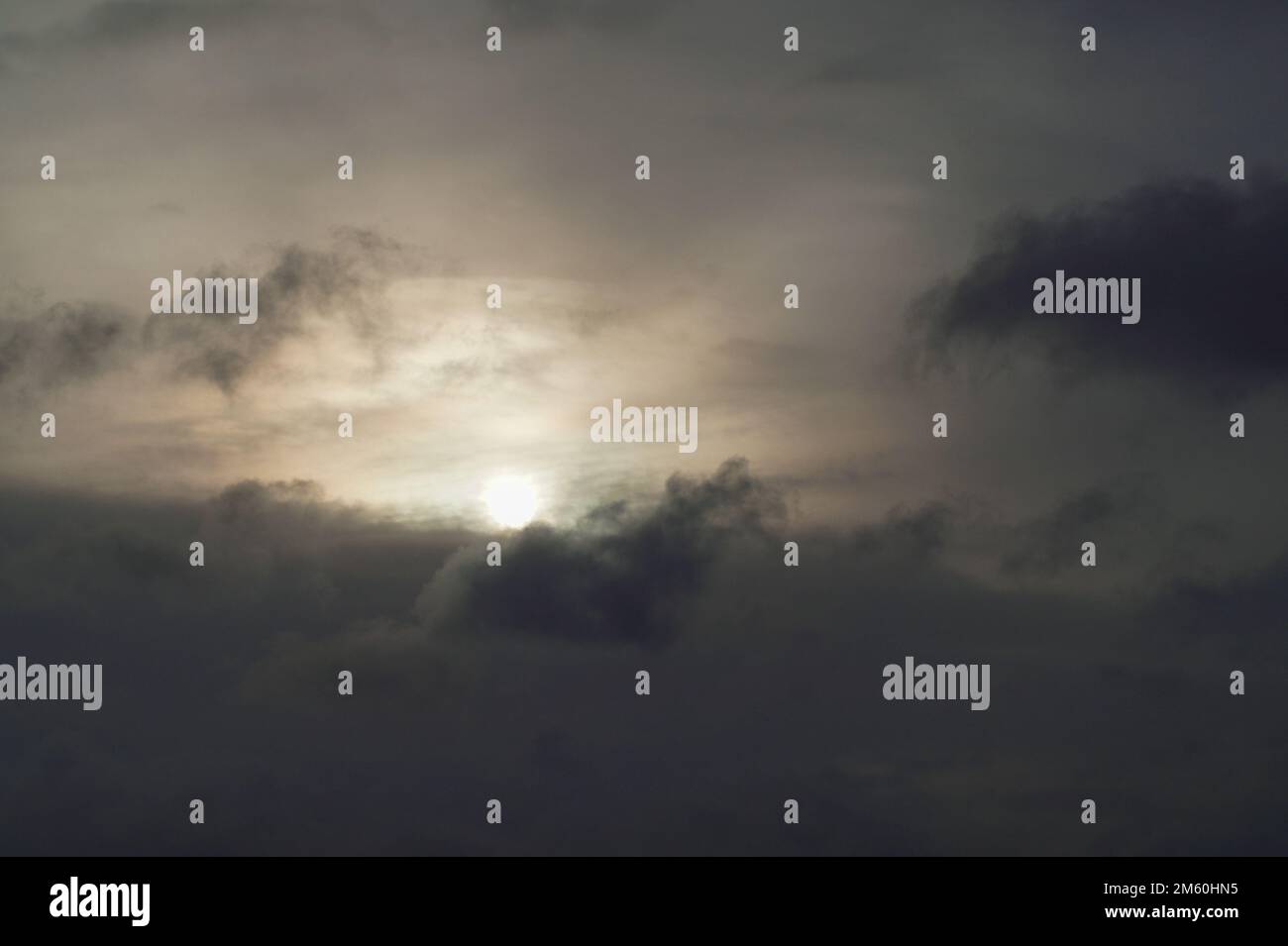 Blick aus dem niedrigen Winkel auf das Sonnenlicht, das durch die Wolken strömt Stockfoto